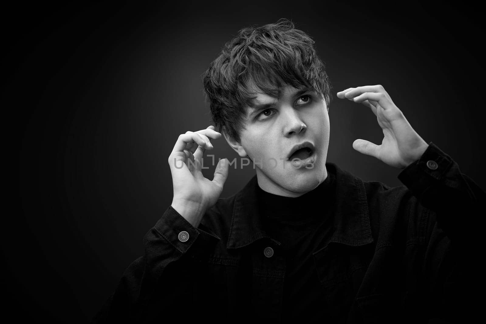 portrait of crazy young man with awesome hairdo grimacing . black and white