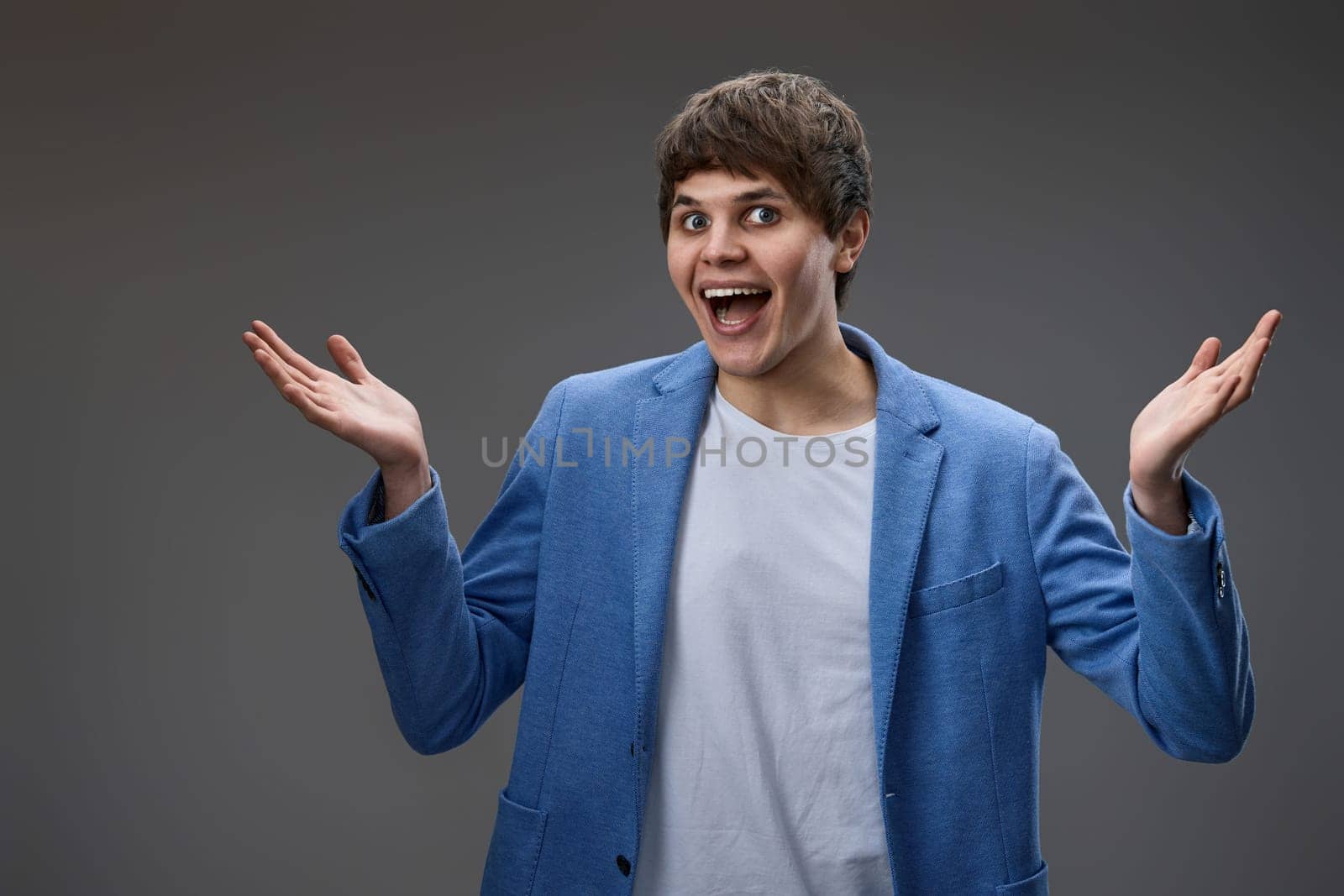 happy surprised man with excited face on gray studio background