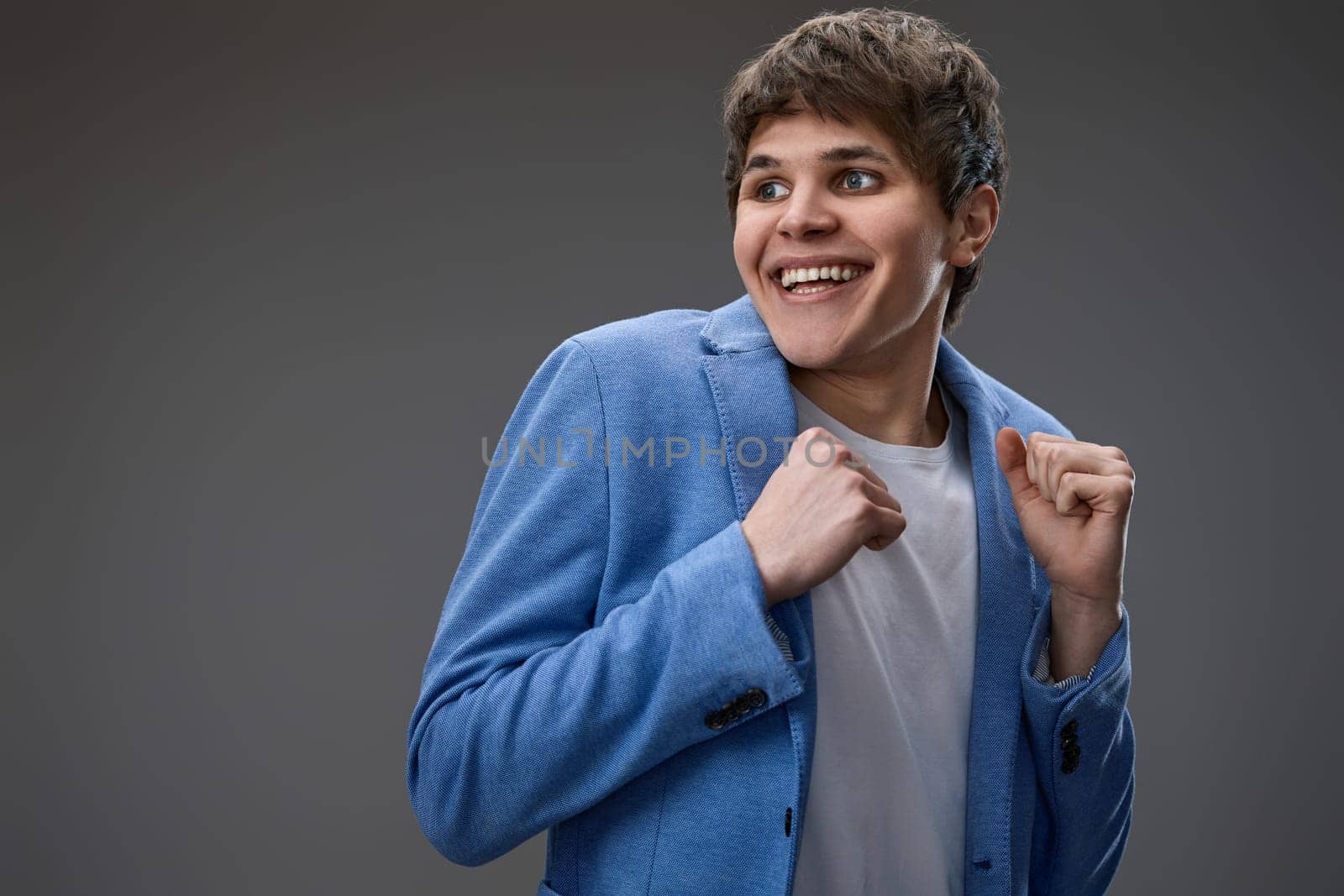 happy shocked man with surprise expression and excited face on gray studio background
