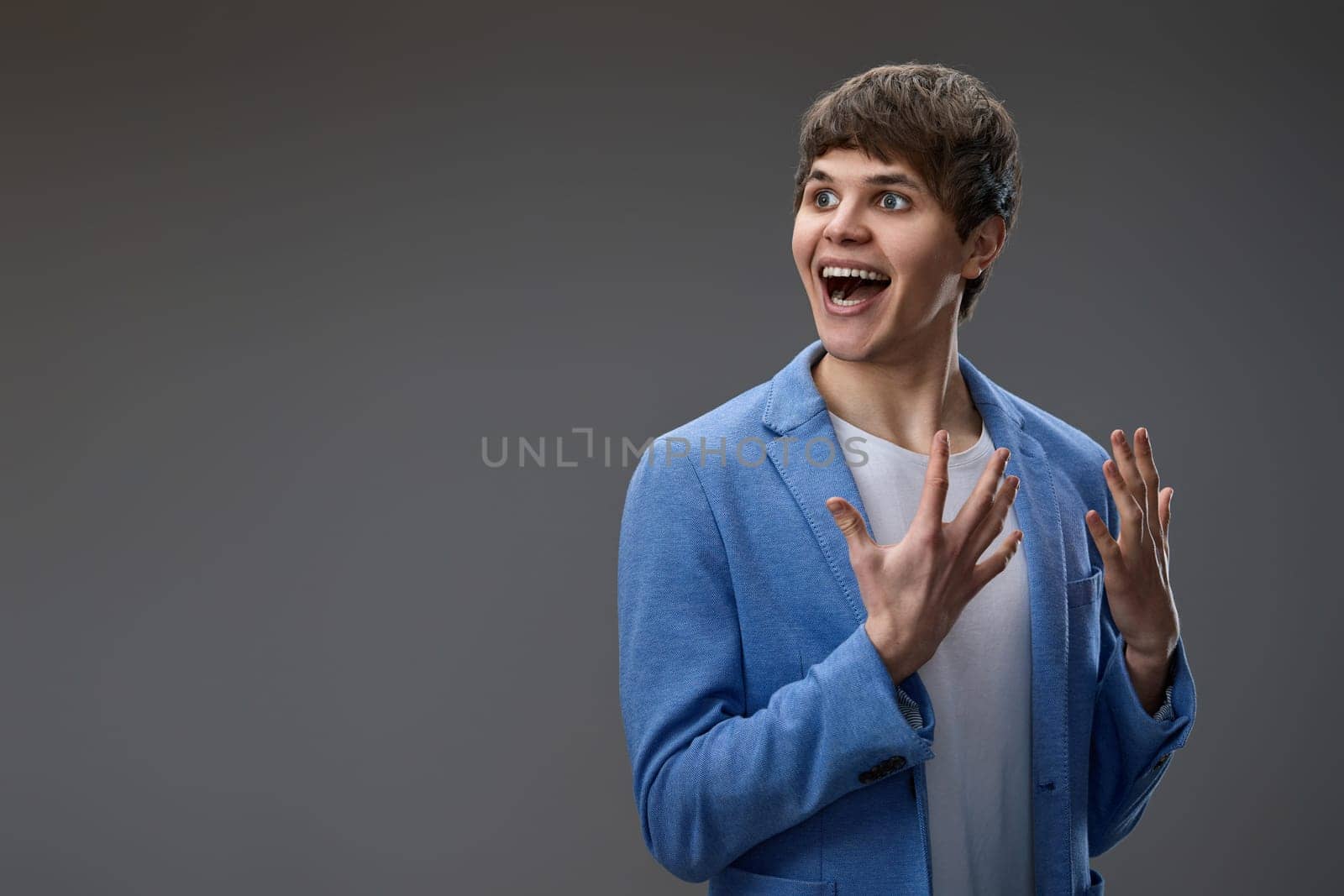 happy shocked man with surprise expression and excited face on gray studio background