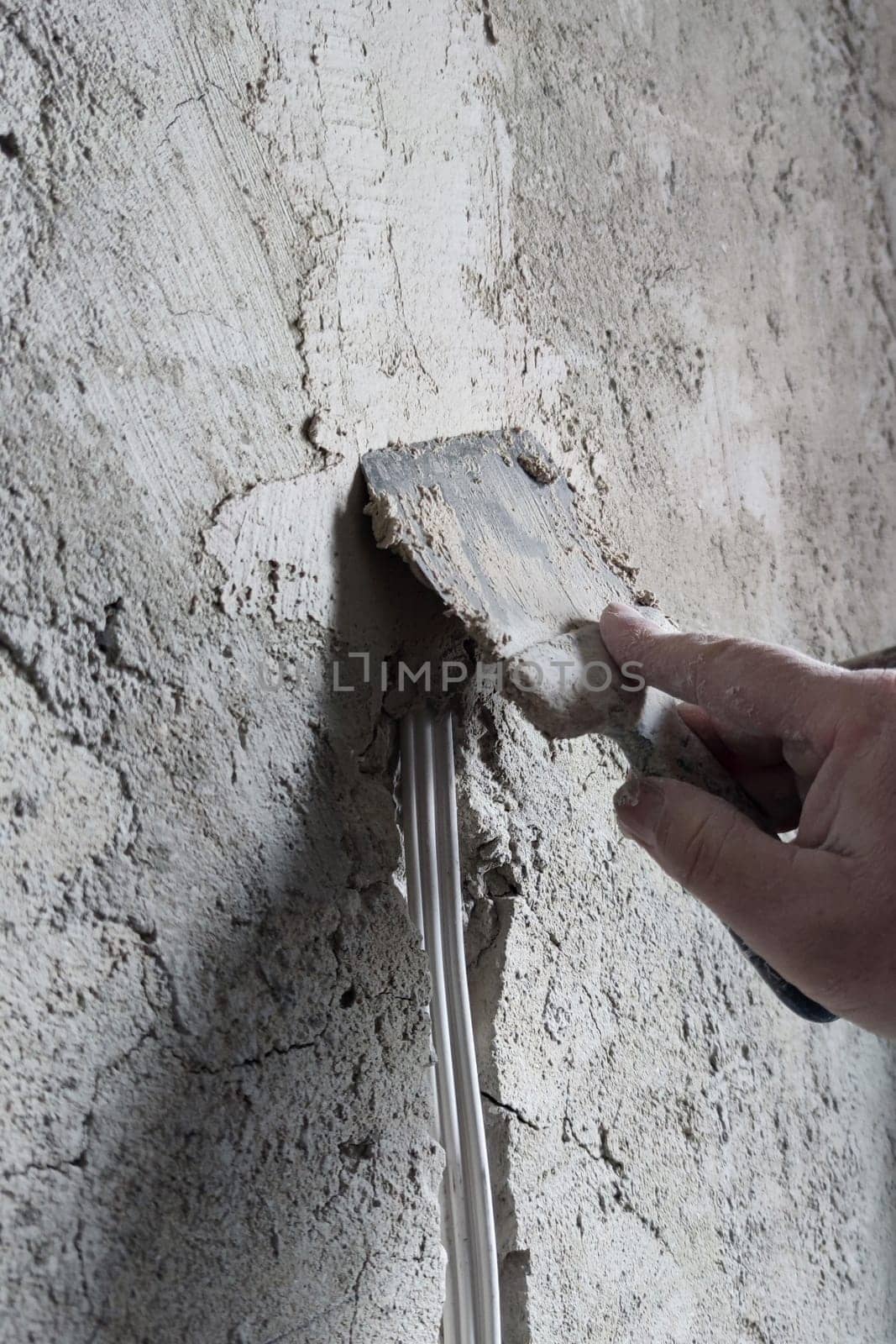 Seal the strobe with a cable in the wall with cement mortar close-up