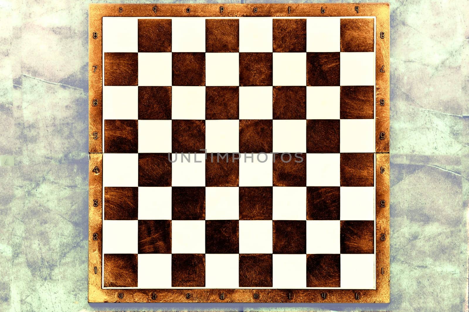 a square board divided into sixty-four alternating dark and light squares, used for playing chess or checkers.