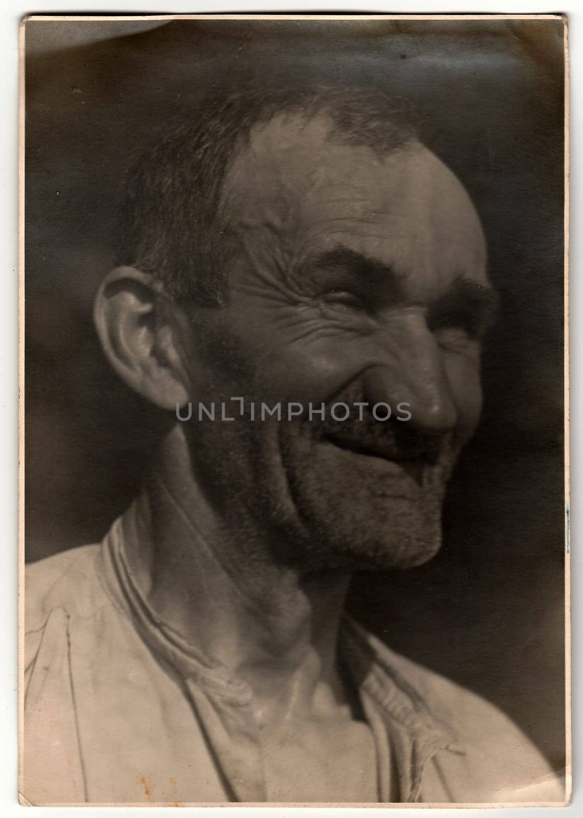 A vintage photo shows old man with unshaven face. by roman_nerud