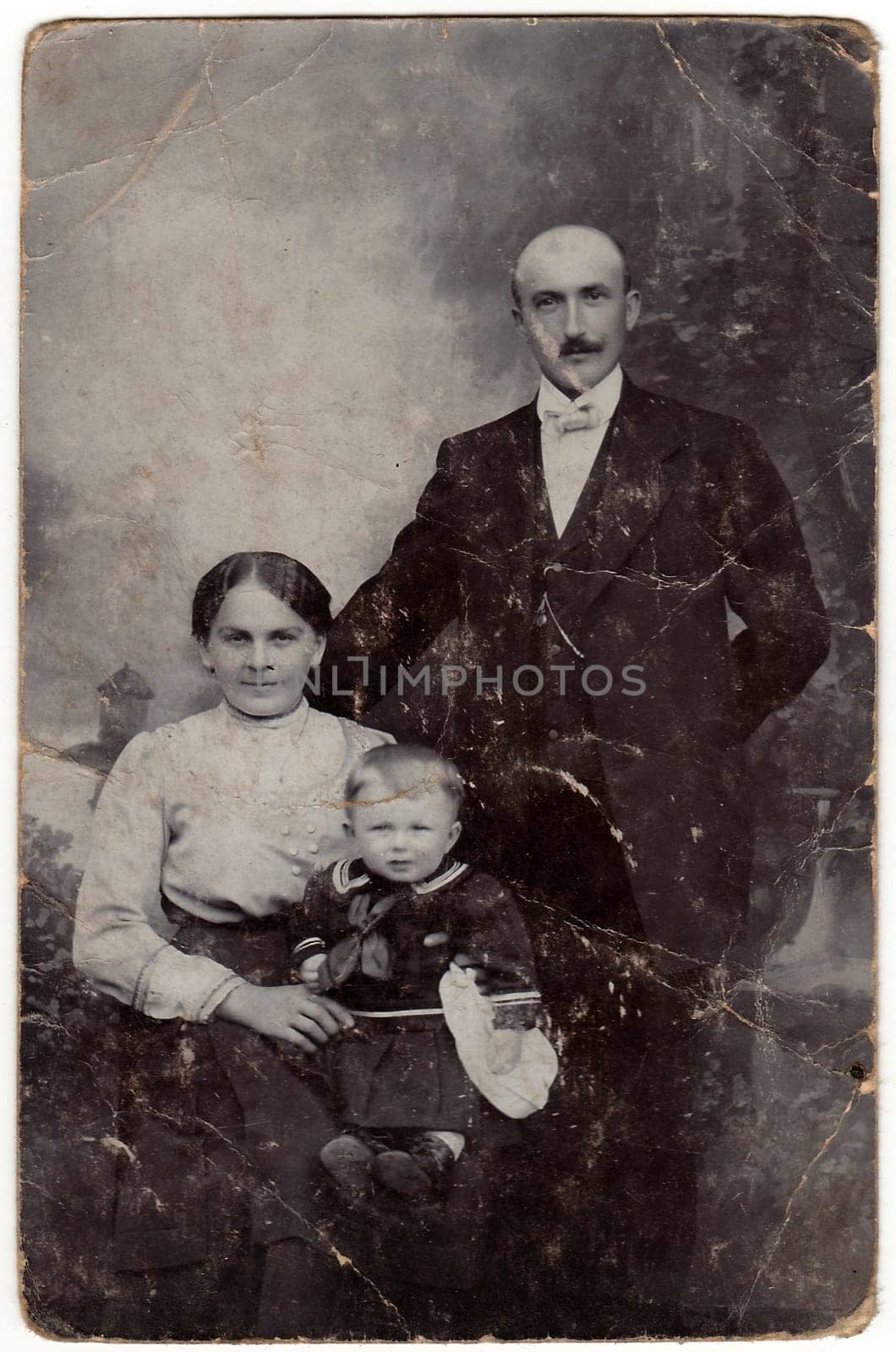 Vintage photo shows family. Small boy wears child sailor costum. by roman_nerud