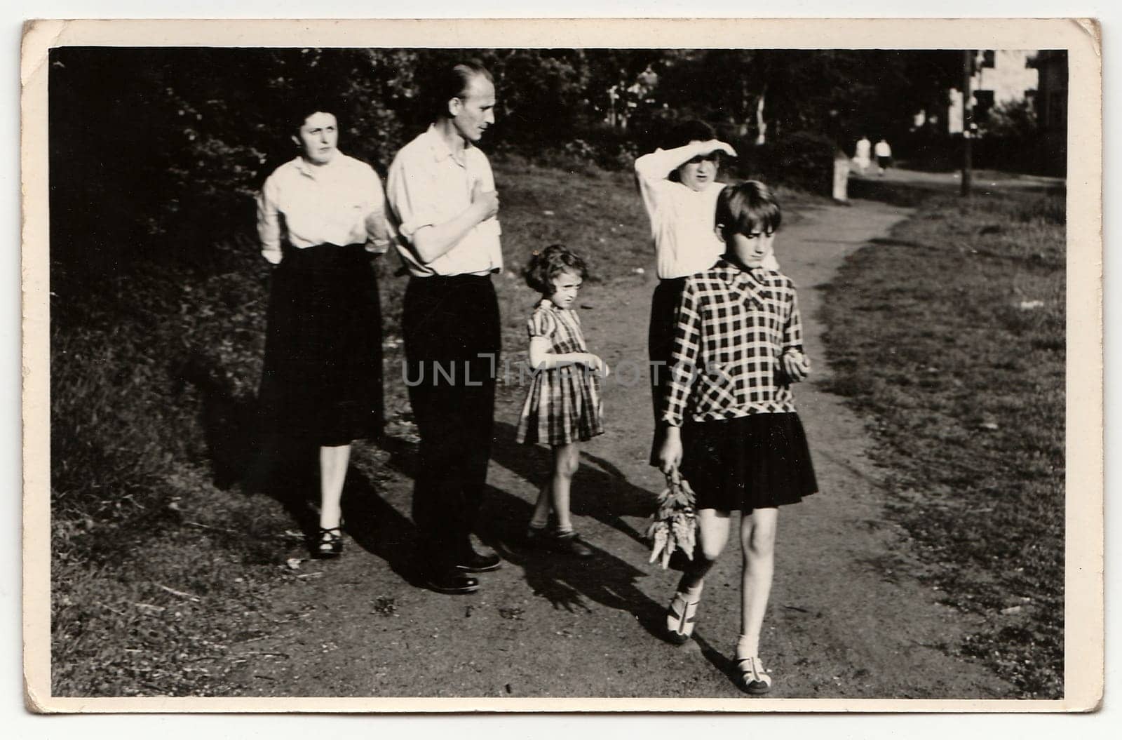 A vintage photo shows family goes for a walk in the city park. Antique black & white photo. by roman_nerud