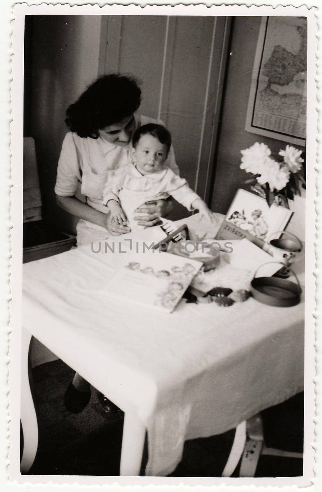 HODONIN, THE CZECHOSLOVAK REPUBLIC - CIRCA 194: A vintage photo shows small toddler girl and her first birthday. Toddler shows cute face.