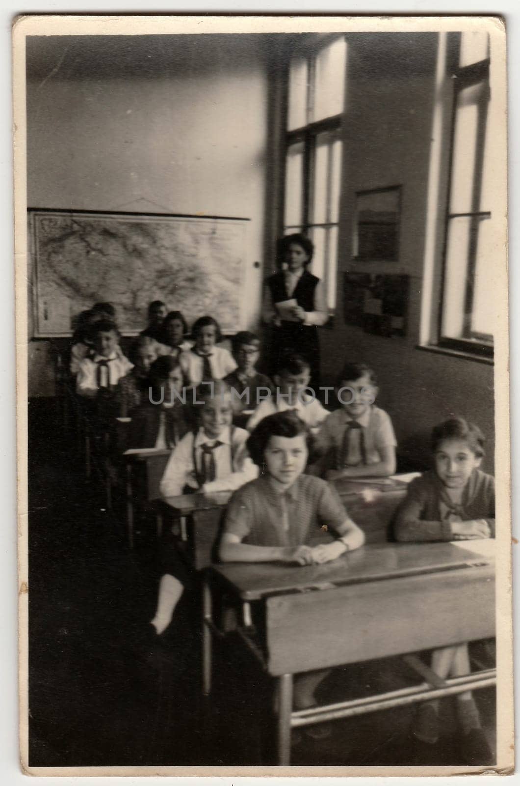 Vintage photo shows pupil sit at the school desk in classroom. by roman_nerud