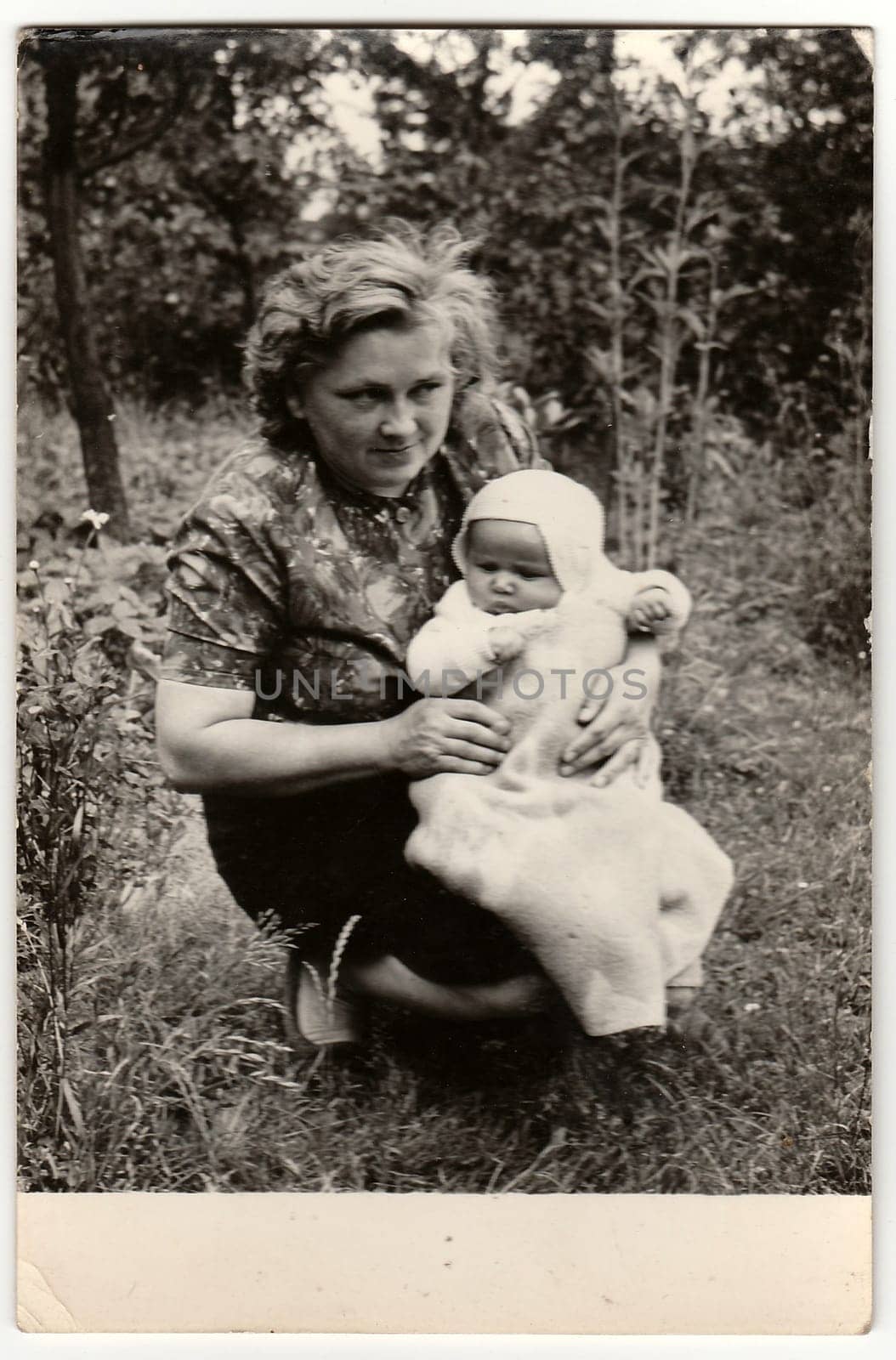 Vintage photo shows young woman cradles baby. by roman_nerud