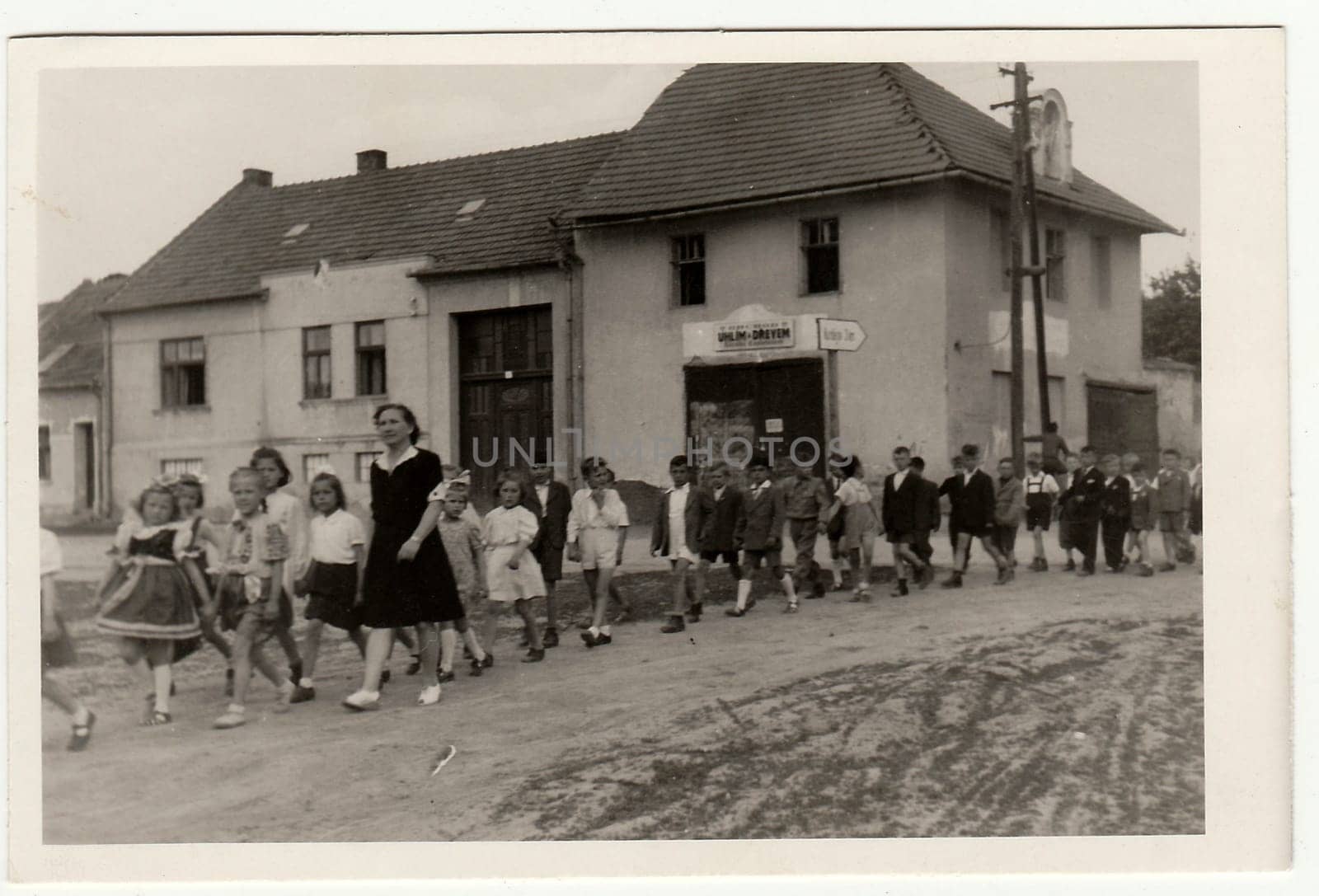 Vintage photo shows female teacher with her pupils go for a walk. by roman_nerud