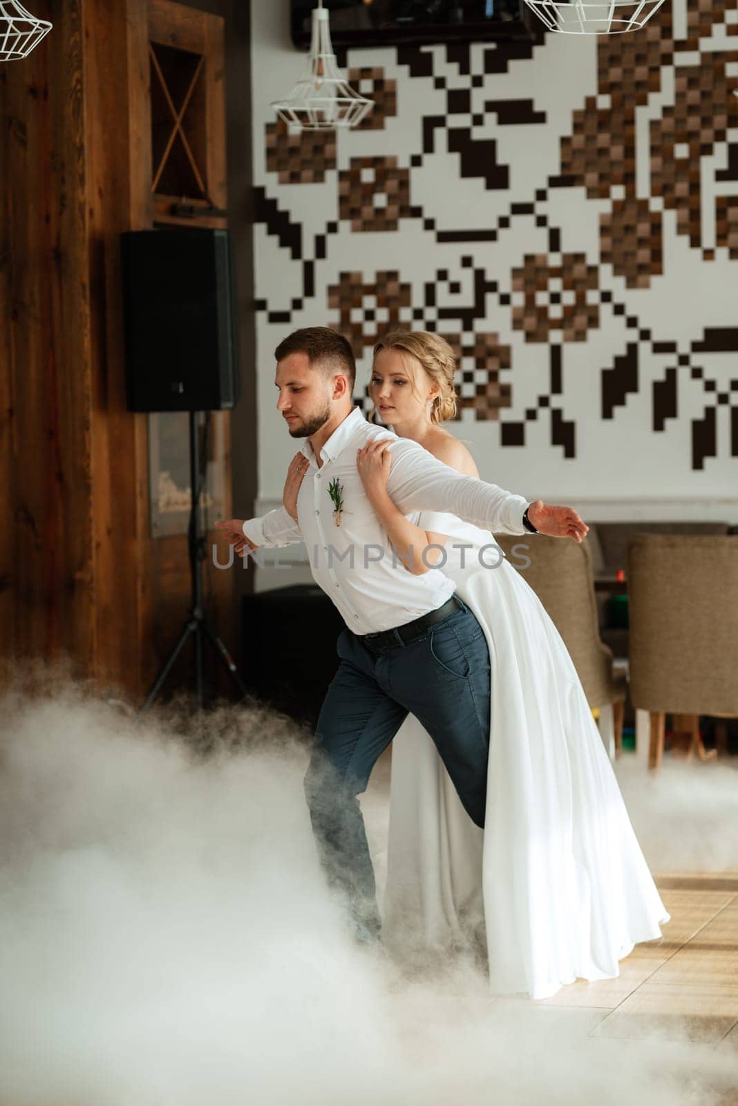 the first dance of the bride and groom inside a restaurant with heavy smoke