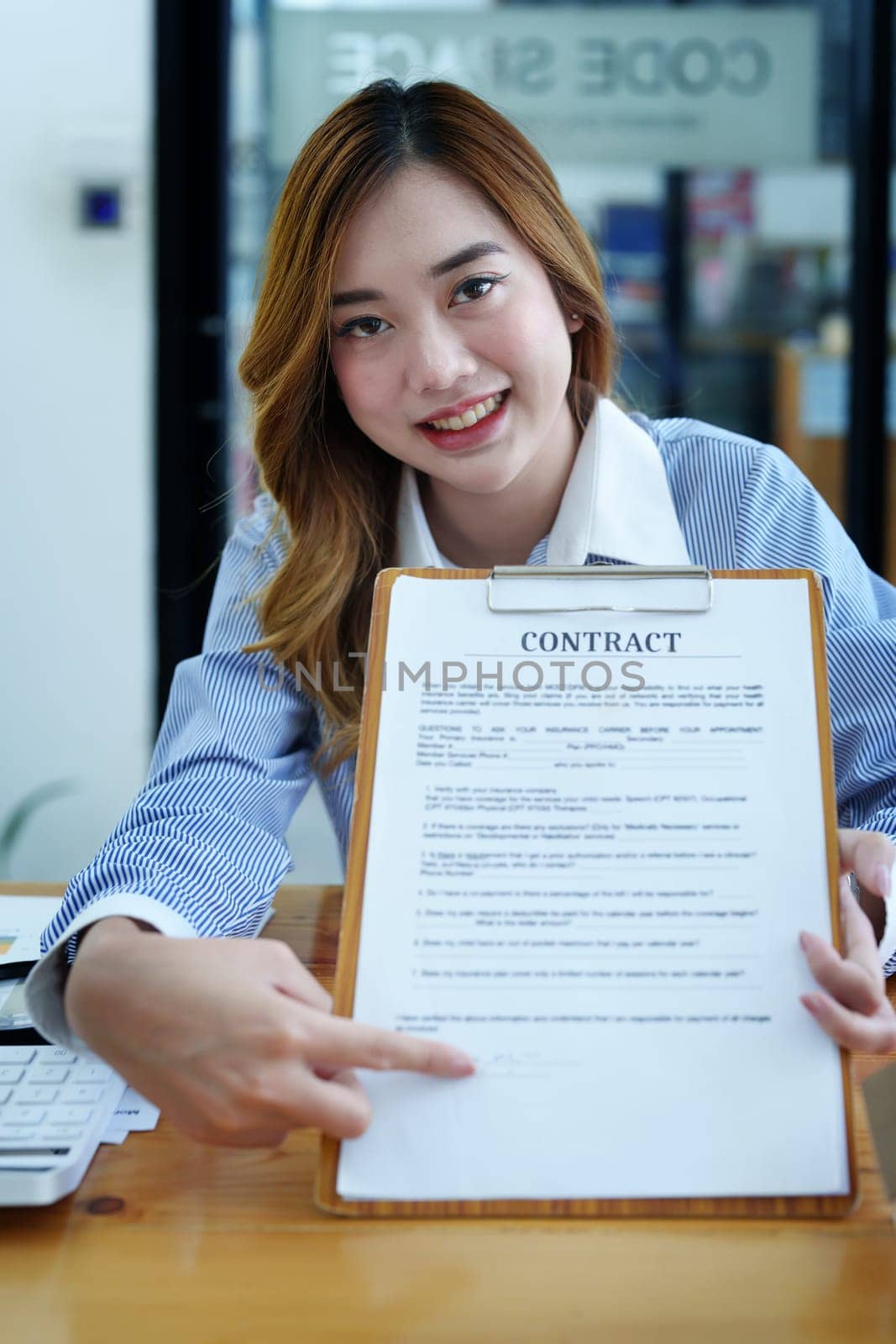 Portrait of a beautiful bank young woman sign credit department of signing approval for a home loan.