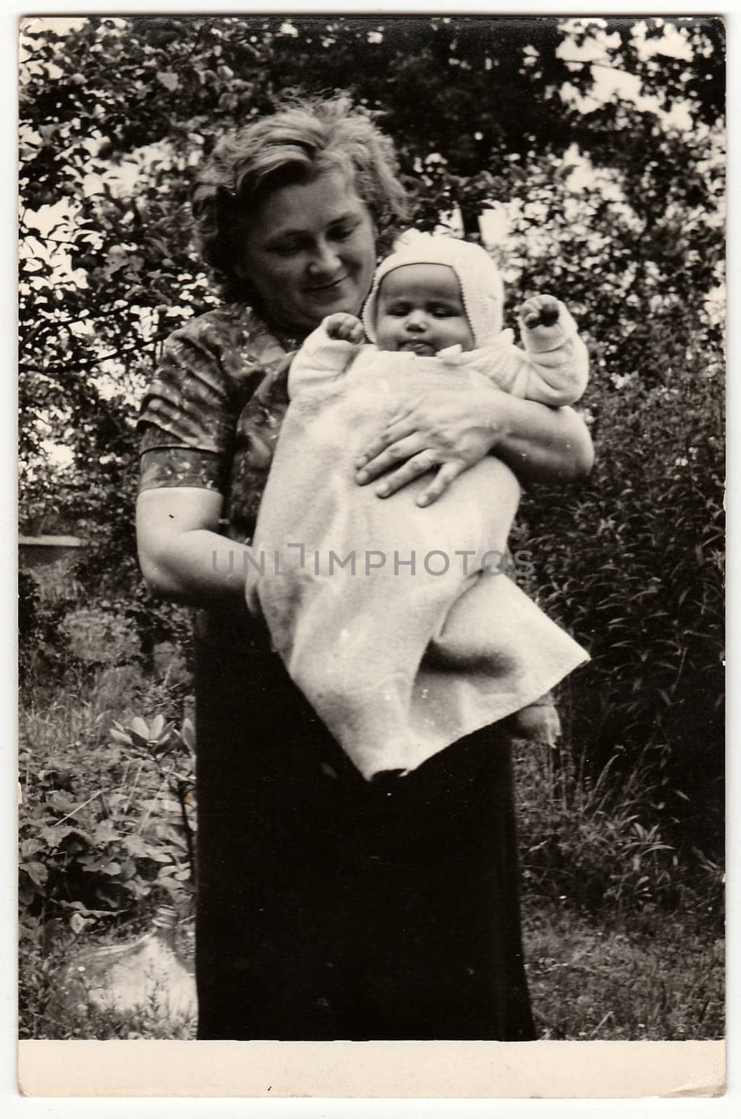 Vintage photo shows young woman cradles baby. by roman_nerud
