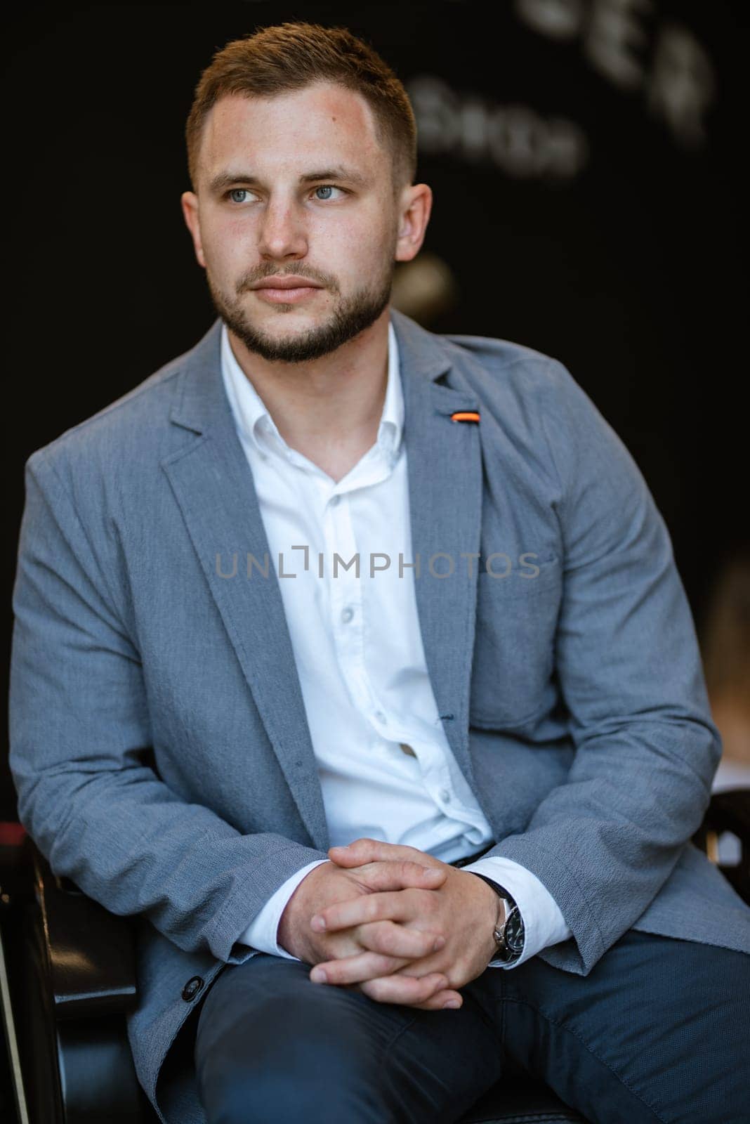 portrait of a young guy groom at the training camp in the barbershop with shaving and styling