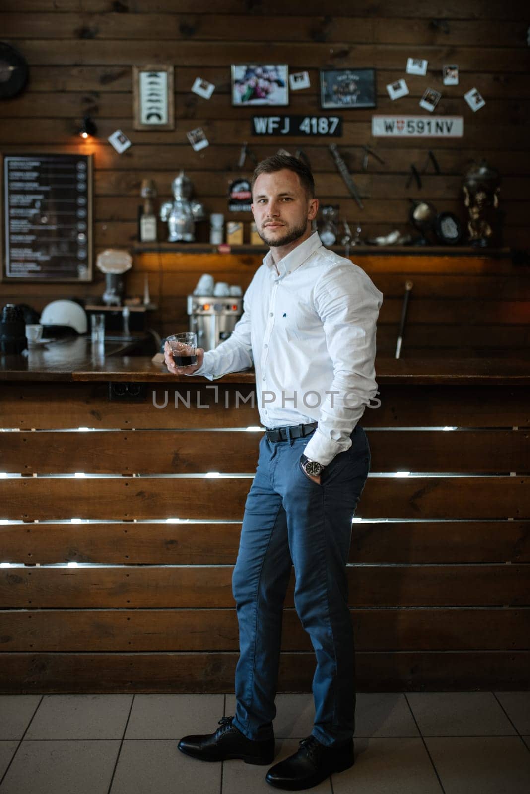 portrait of a young guy groom at the training camp in the barbershop with shaving and styling