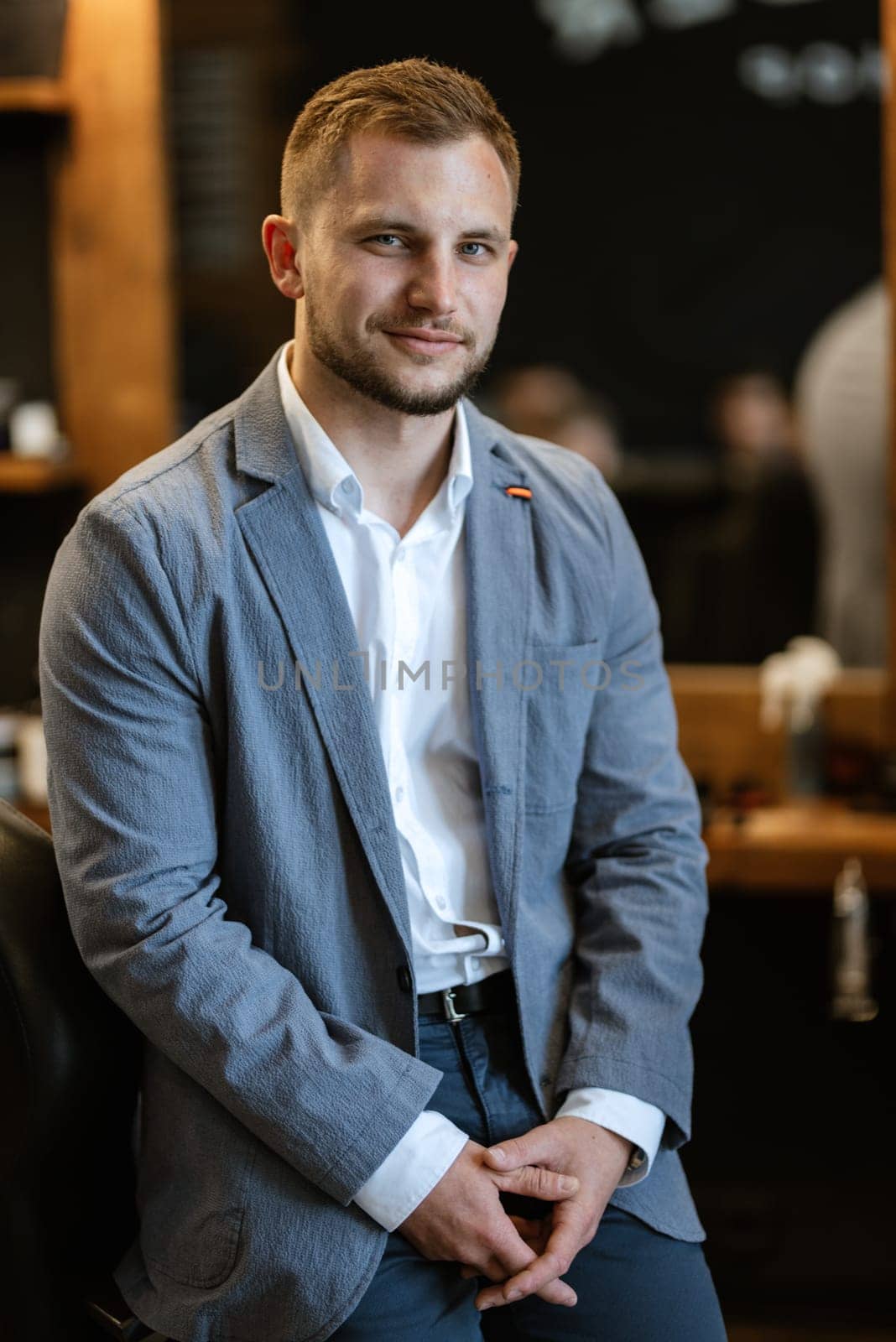 portrait of a young guy groom at the training camp in the barbershop with shaving and styling