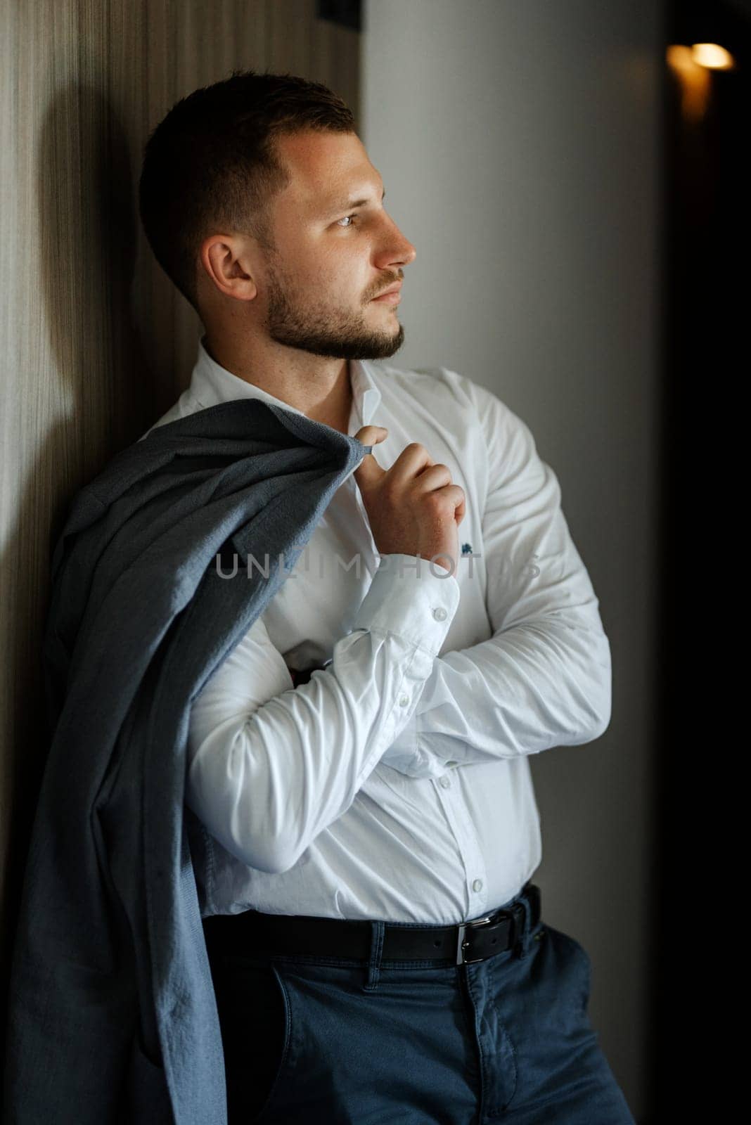 portrait of smiling groom with beard in blue color suit