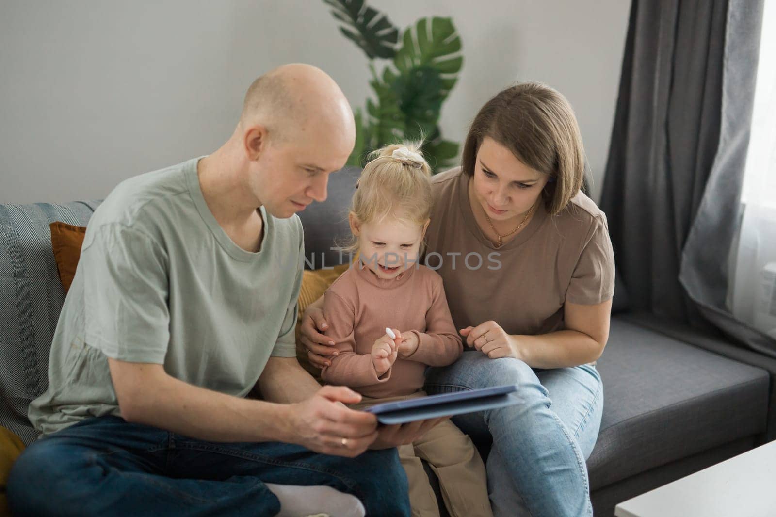 Deaf child girl with cochlear implant studying to hear sounds and have fun with mother and father - recovery after cochlear Implant surgery and rehabilitation concept by Satura86