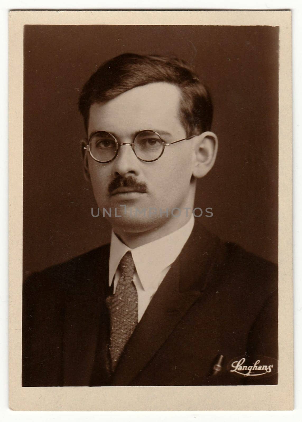 Vintage photo shows young man with glasses and moustache. Antique black white photo with sepia tint by roman_nerud