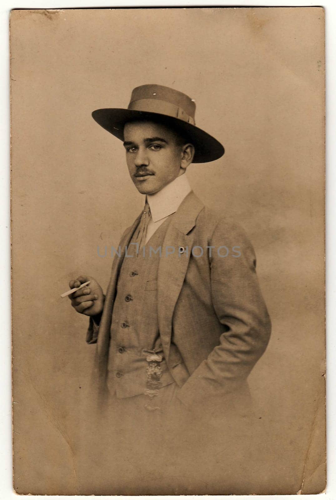 OLOMOUC, THE CZECHOSLOVAK REPUBLIC - CIRCA 1920s: Vintage photo shows dandy man with cigarette and hat. Antique black white photo.