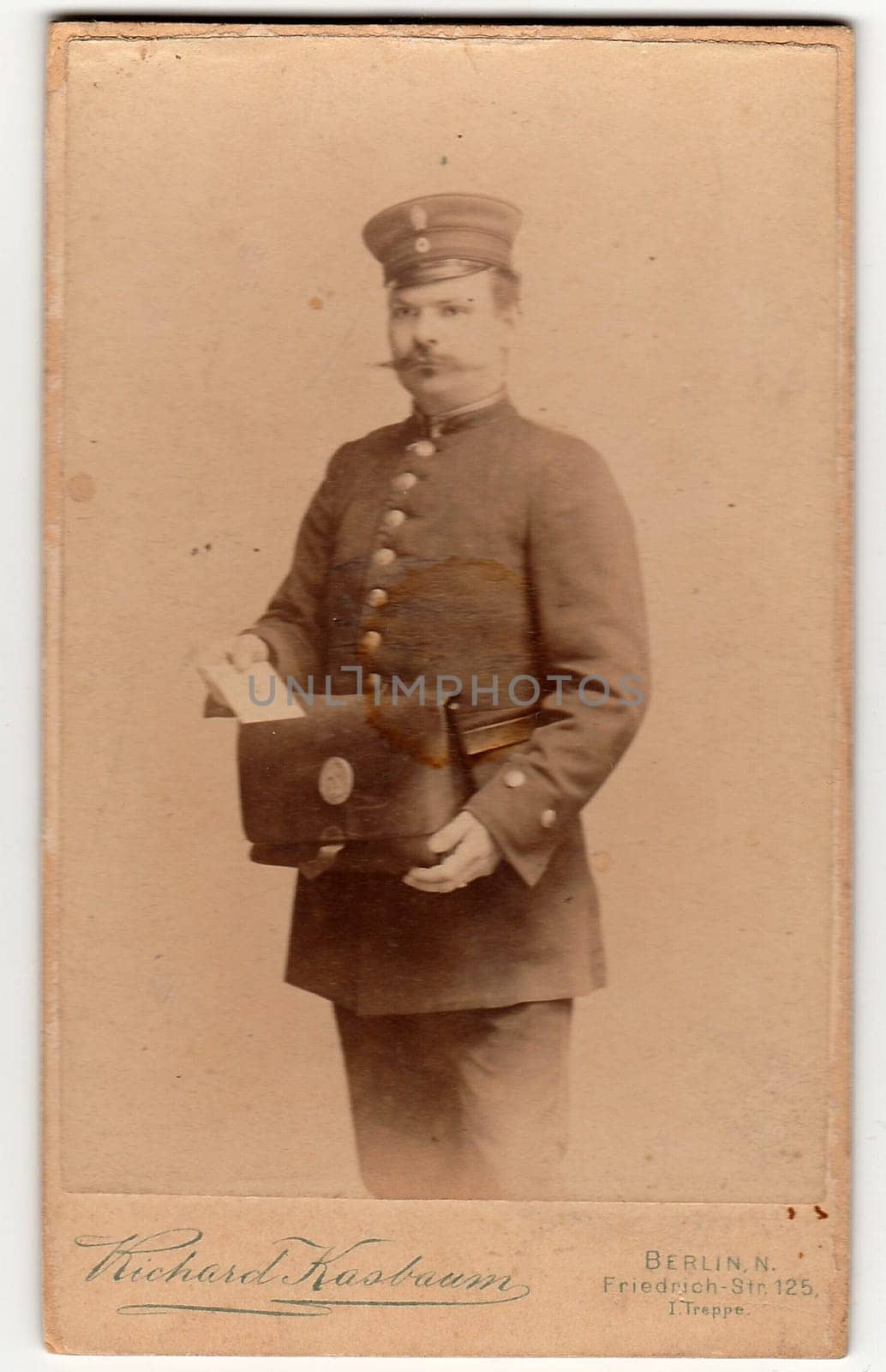 BERLIN, GERMANY - CIRCA 1895: Vintage cabinet card shows man wears a postman uniform. Antique black white photo.