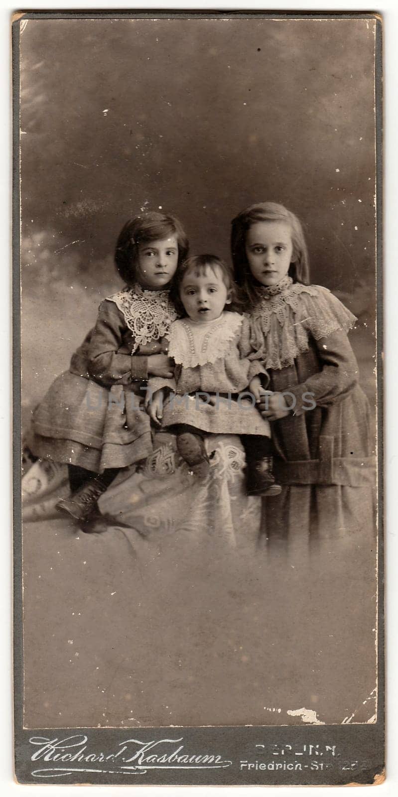 BERLIN, GERMANY- CIRCA 1905: A vintage cabinet card shows cute children girls . Antique black white photo.