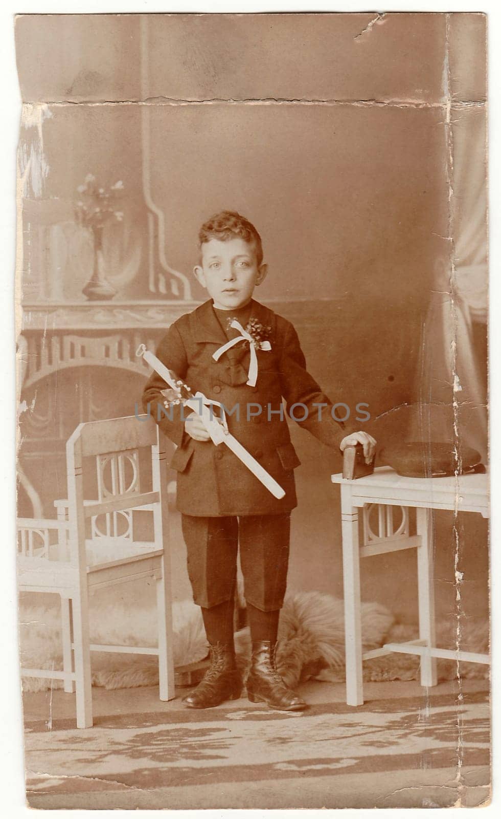 HODONIN, AUSTRIA-HUNGARY - CIRCA 1910s: A vintage photo shows young boy - the first holy communion. Antique black white photo with sepia tint.