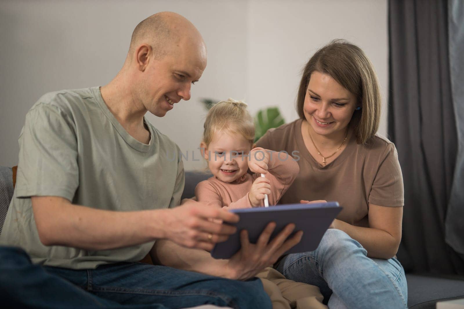 Deaf child girl with cochlear implant studying to hear sounds and have fun with mother and father - recovery after cochlear Implant surgery and rehabilitation concept by Satura86