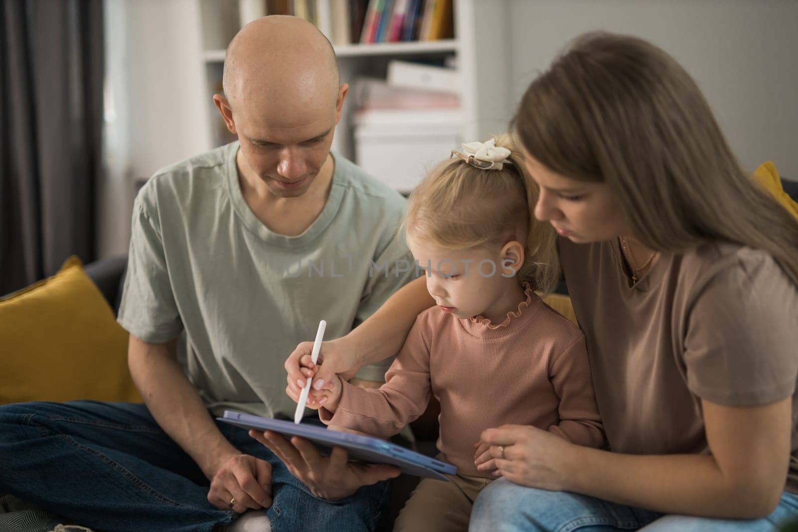 Deaf child girl with cochlear implant studying to hear sounds and have fun with mother and father - recovery after cochlear Implant surgery and rehabilitation concept by Satura86