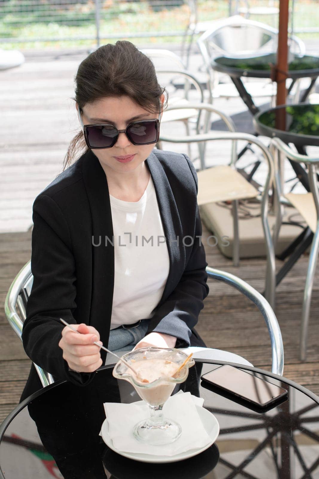 a business woman in sunglasses eats her favorite delicious ice cream,elegant by KaterinaDalemans