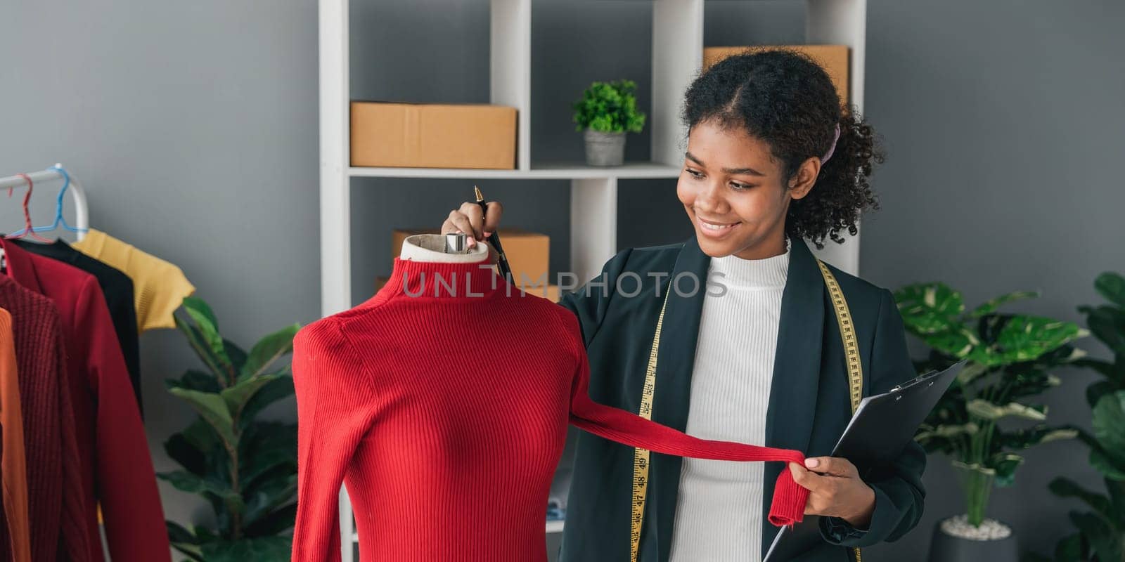 portrait smile black woman working on clothes in tailoring atelier. Attractive beautiful young female fashion designer smile after success in make new handmade suit in workshop...