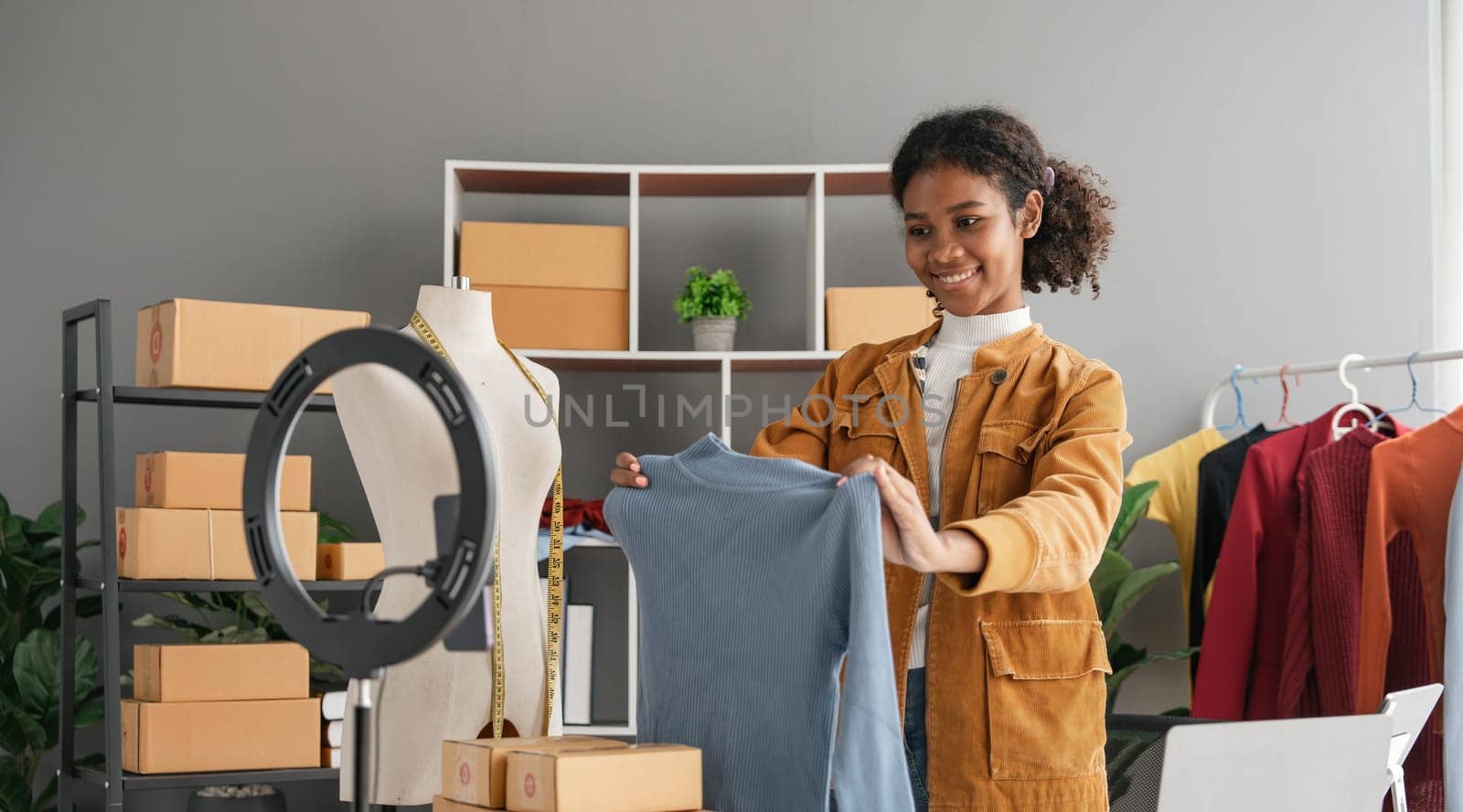 Female stylist Successful Fashion Business.Portrait of Smiling Black woman designer stylish stand and working with color samples. by wichayada