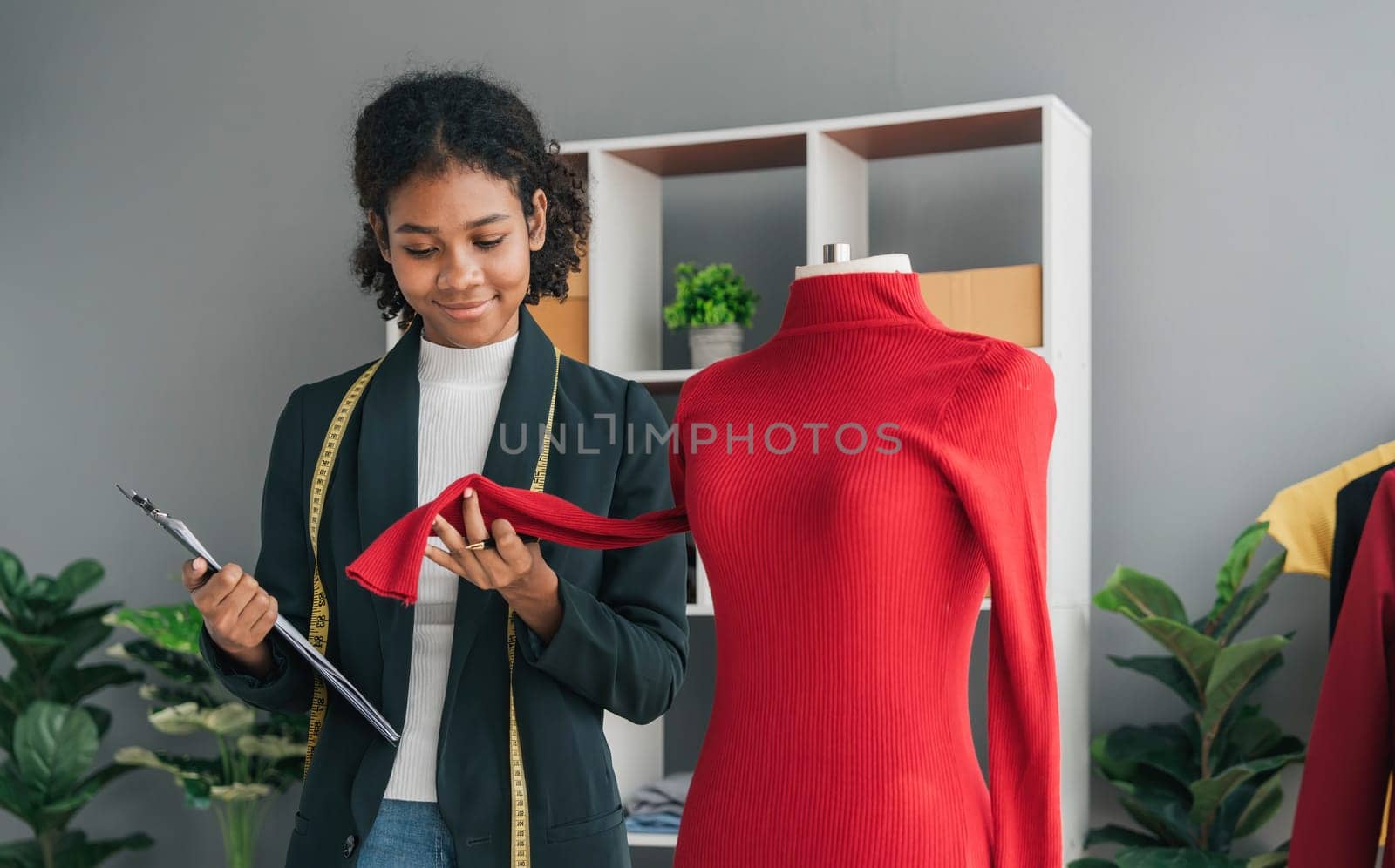 portrait smile black woman working on clothes in tailoring atelier. Attractive beautiful young female fashion designer smile after success in make new handmade suit in workshop...