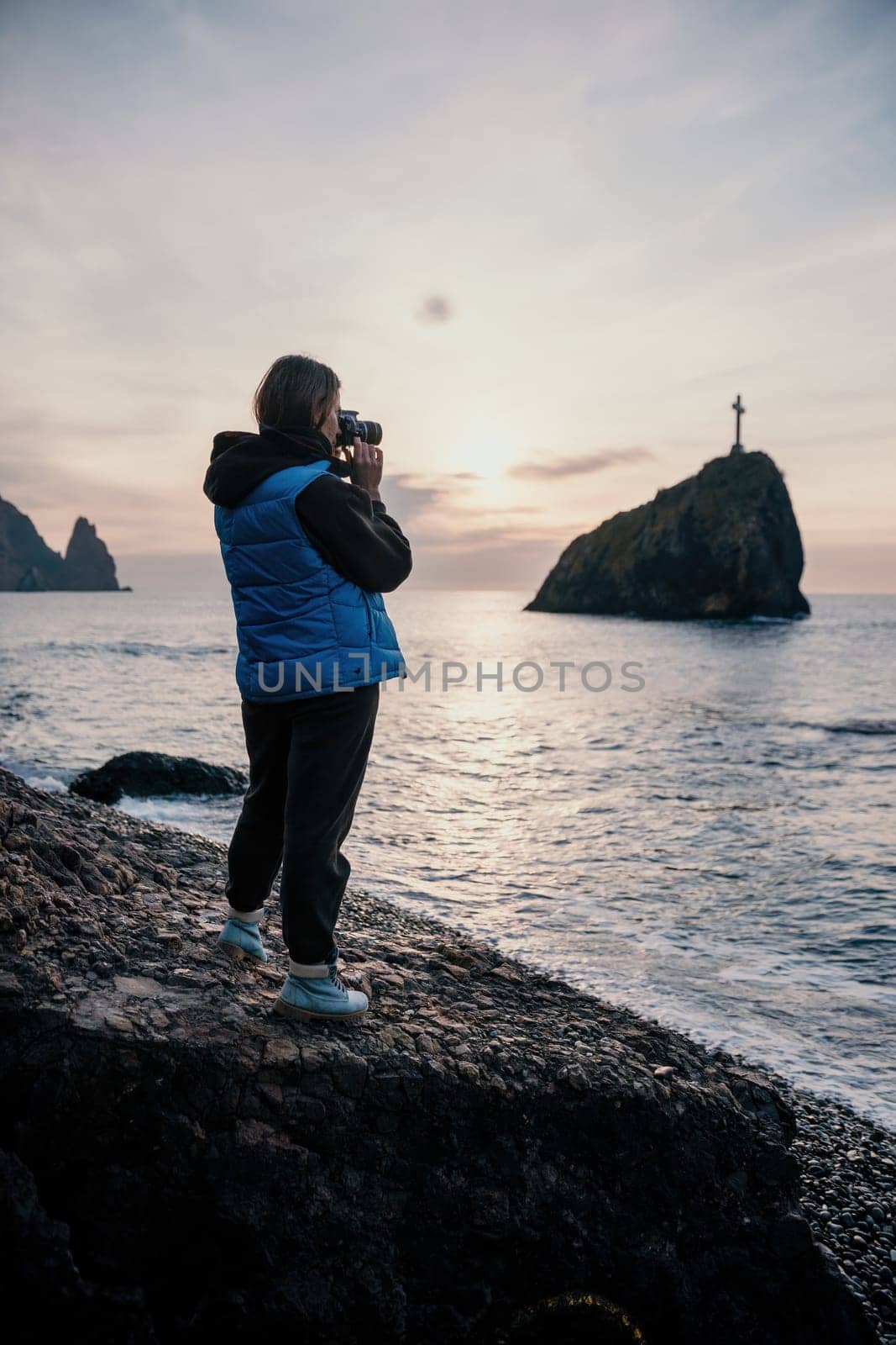 Woman travel sea. Happy tourist enjoy taking picture outdoors for memories. Woman traveler looks at sea bay of mountains, sharing travel adventure journey by panophotograph