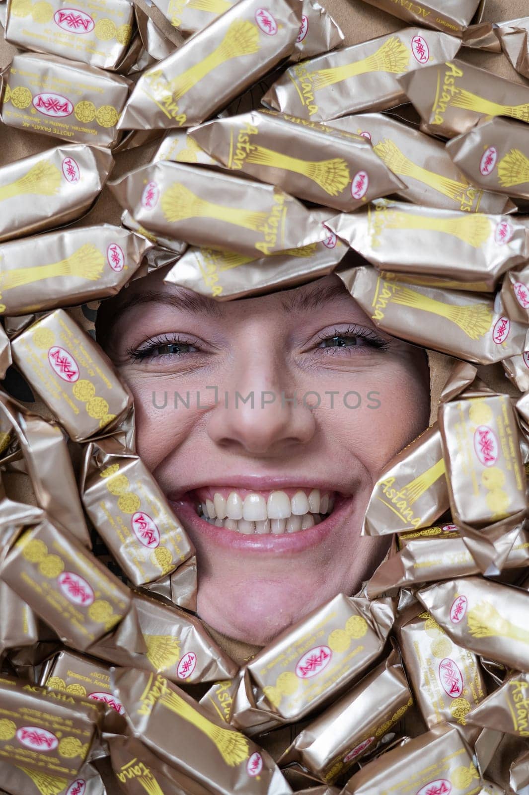 The face of a caucasian woman surrounded by Rakhat chocolates. by mrwed54