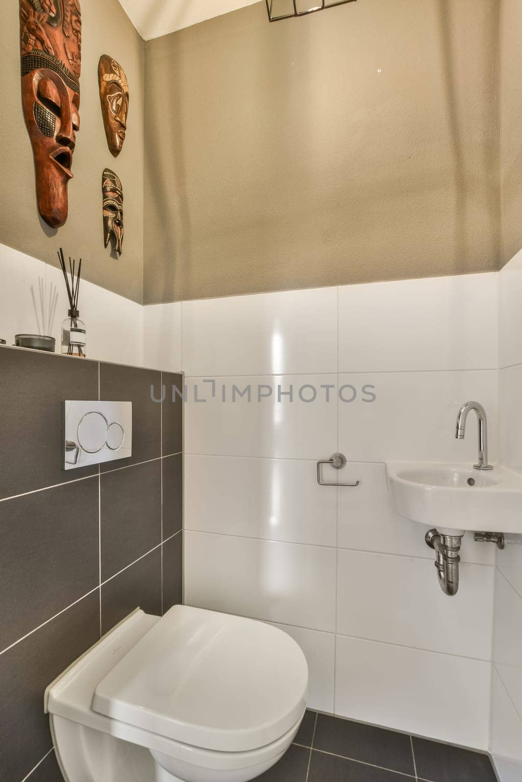 a toilet and sink in a bathroom with white tiles on the wall behind it is an image of a man's face