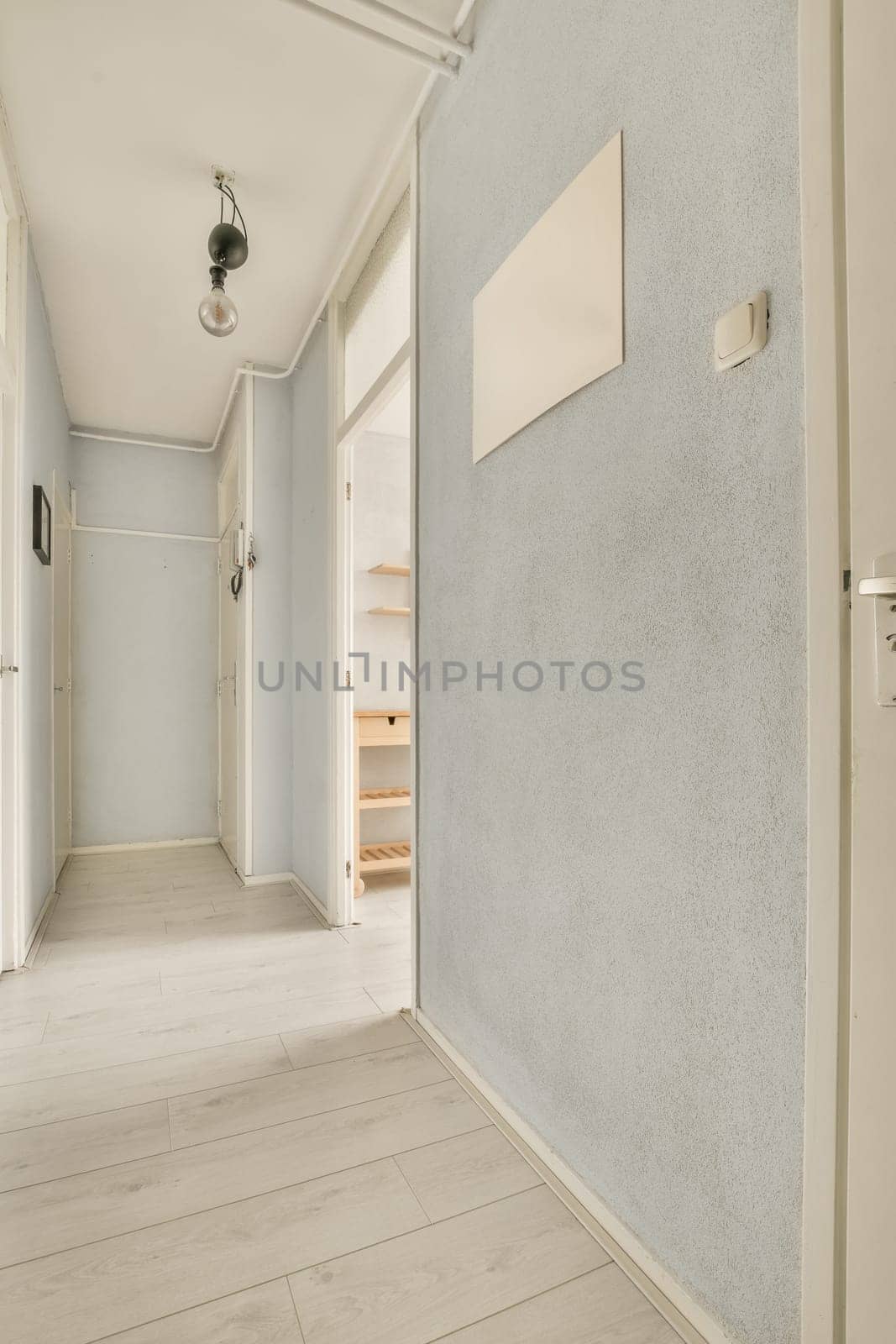 a hallway with a white wall with a white door by casamedia