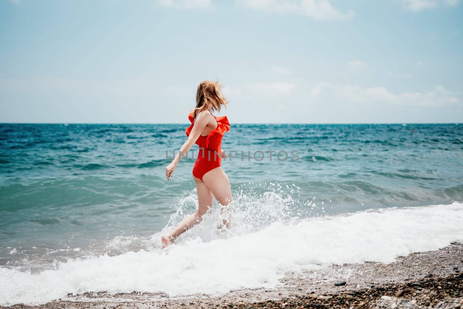 Pretty young blonde woman walking on the beach in summer, having fun, walks carefree on the seaside . Portrait beautiful young woman relax smile around beach sea ocean in holiday vacation travel trip.
