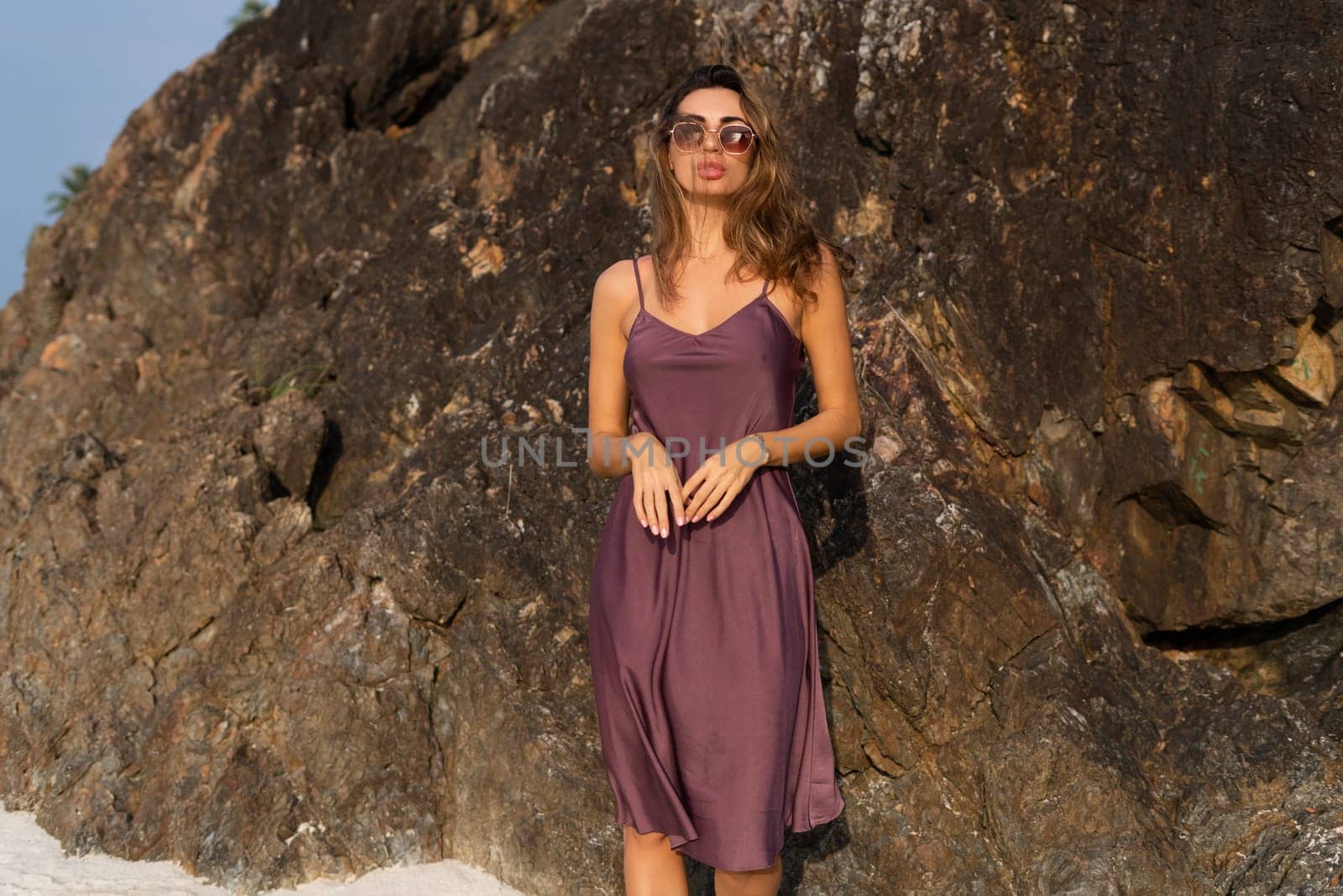 Stylish romantic tender sensual woman in silk dress and sunglasses on the beach at sunset by kroshka_nastya