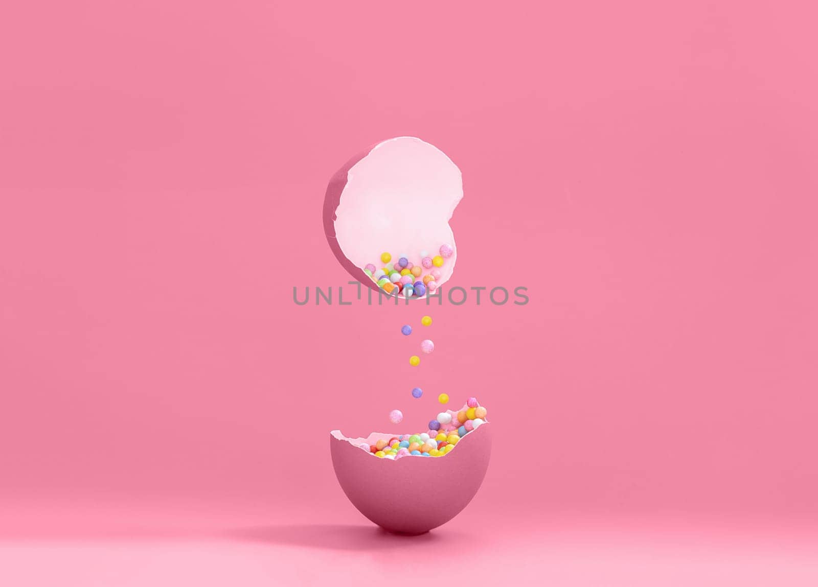 Broken decorative easter egg with colorful confetti. Minimal composition, vivid color pastel pink background. Copy space