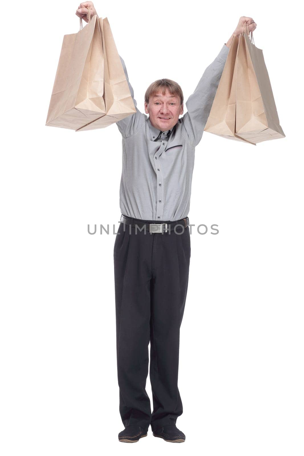 full length. happy mature man showing his shopping bags. isolated on a white background.