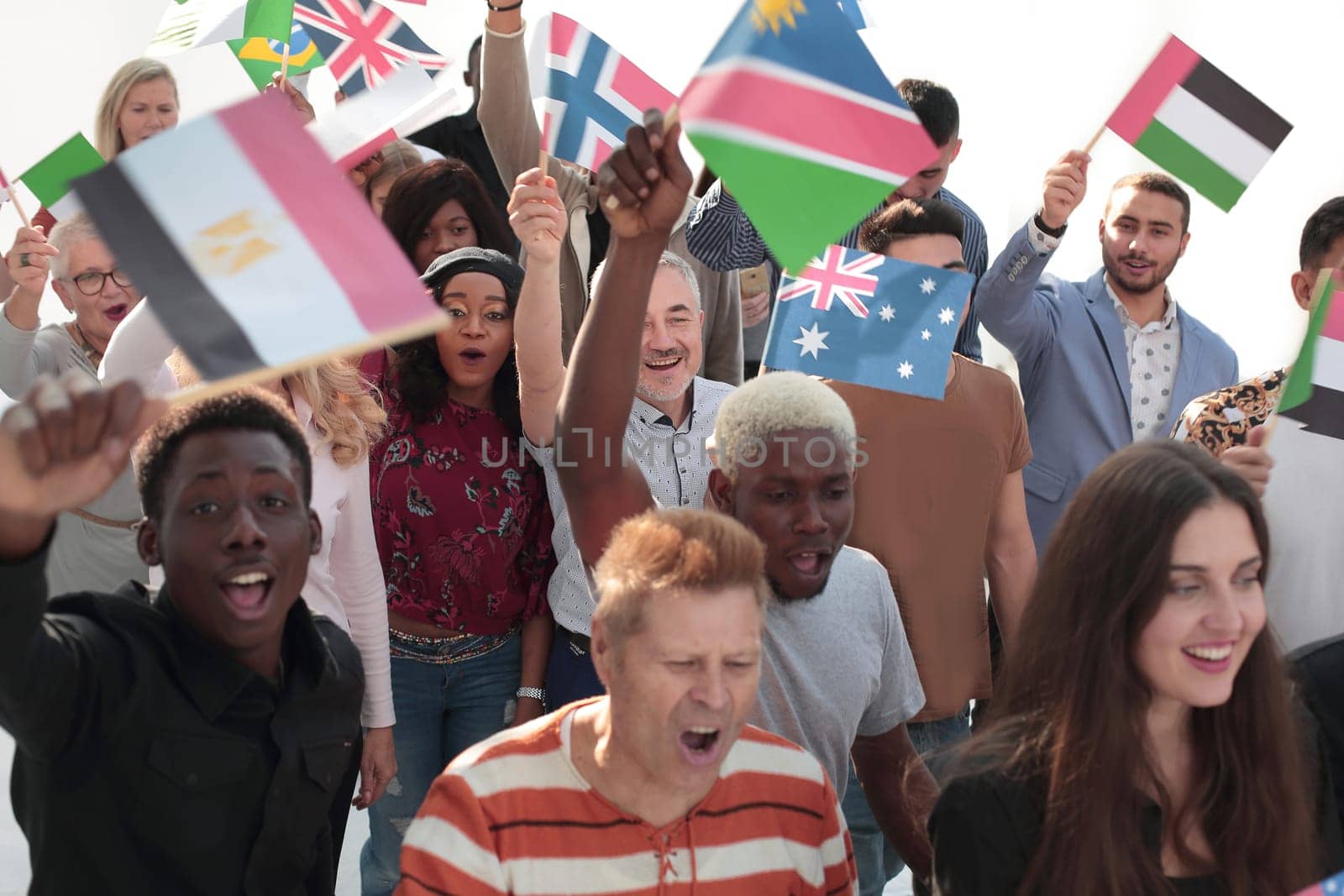 Multiethnic group of happy young peple walking ahead with flags of different countries