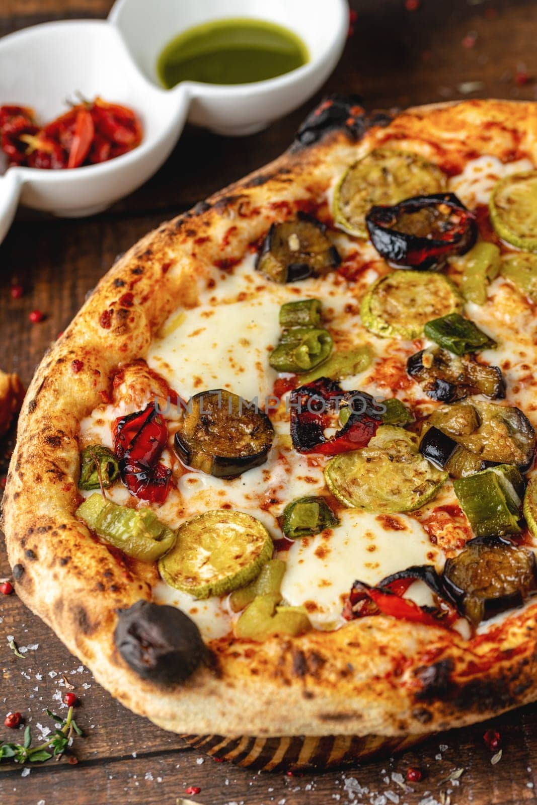 Vegetarian pizza with eggplant, zucchini and mushrooms on dark stone table by Sonat