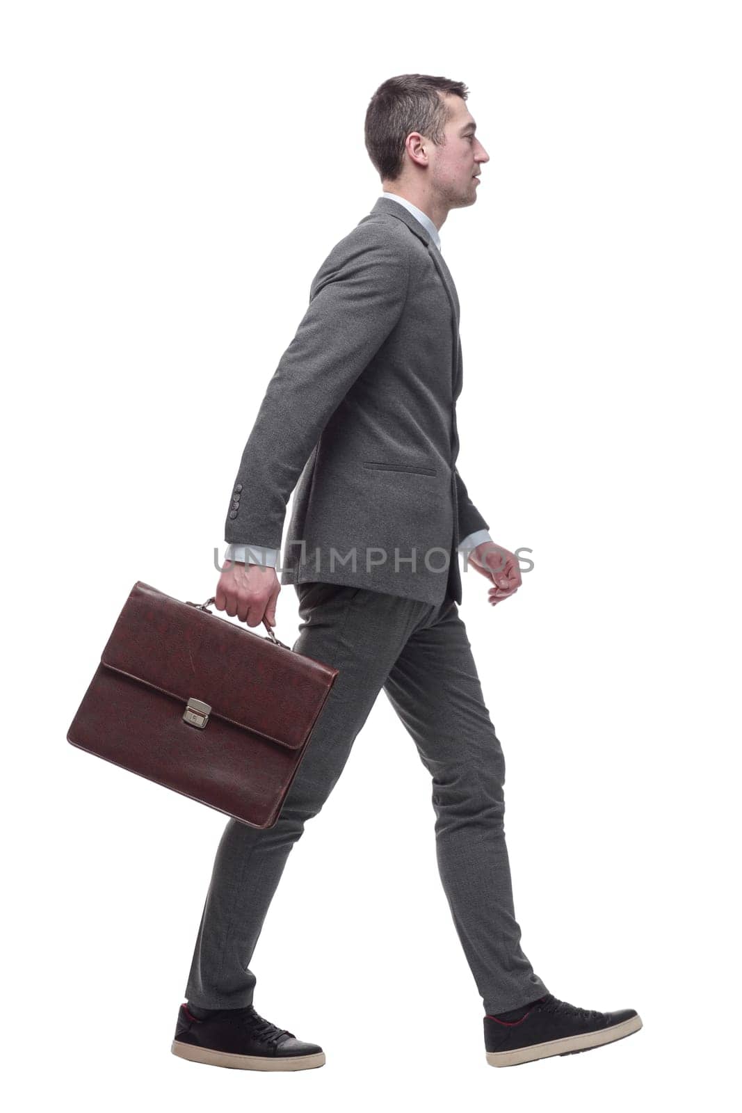 in full growth. a business man with a leather briefcase striding forward. isolated on a white background.