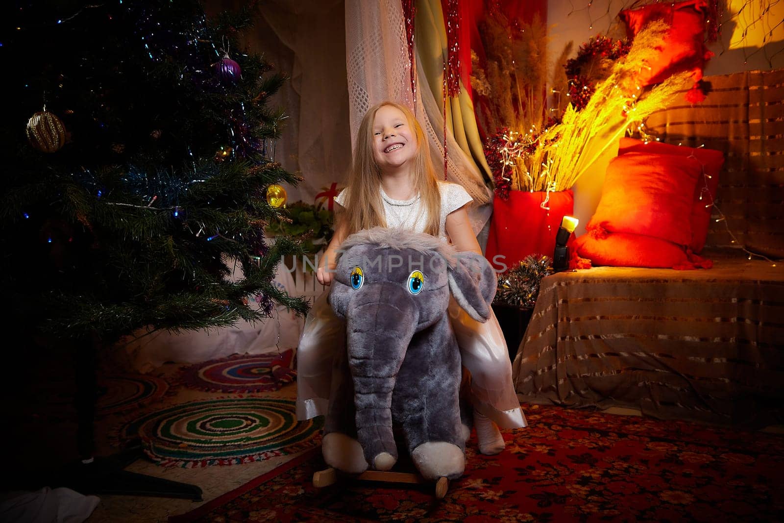 Beautiful girl in nice white dress on the background of a Christmas tree. New year and christmas concept by keleny