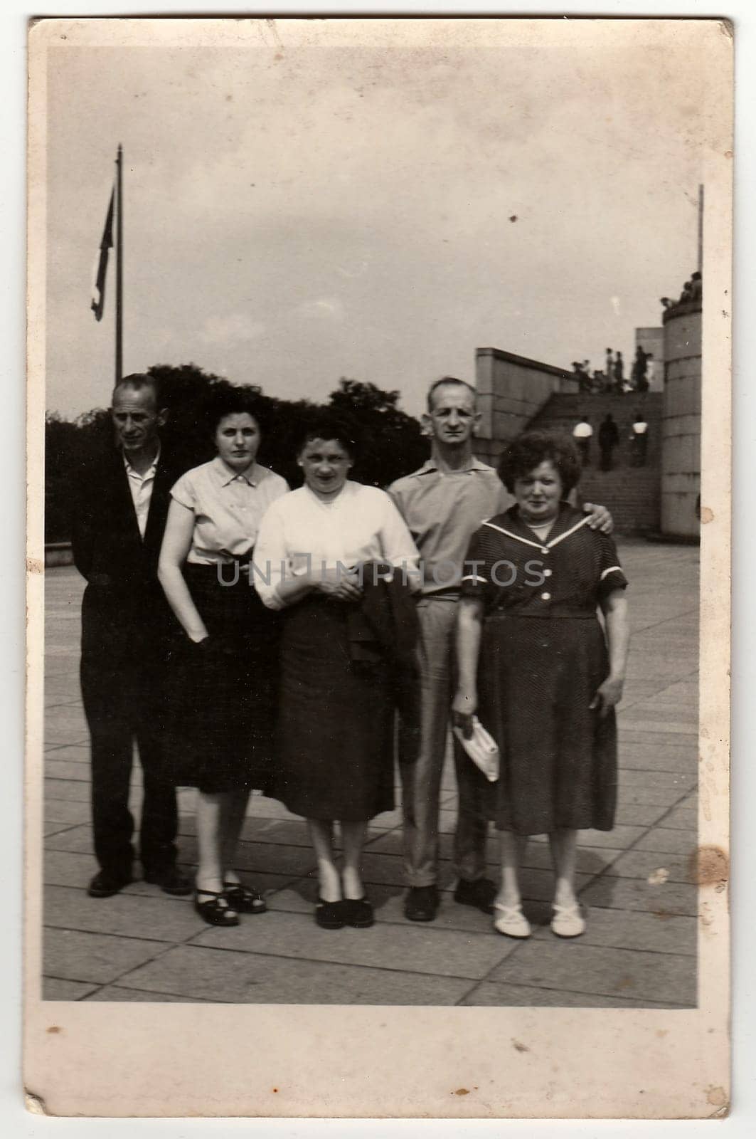 Vintage photo shows group of people stands in front of communist monument. by roman_nerud