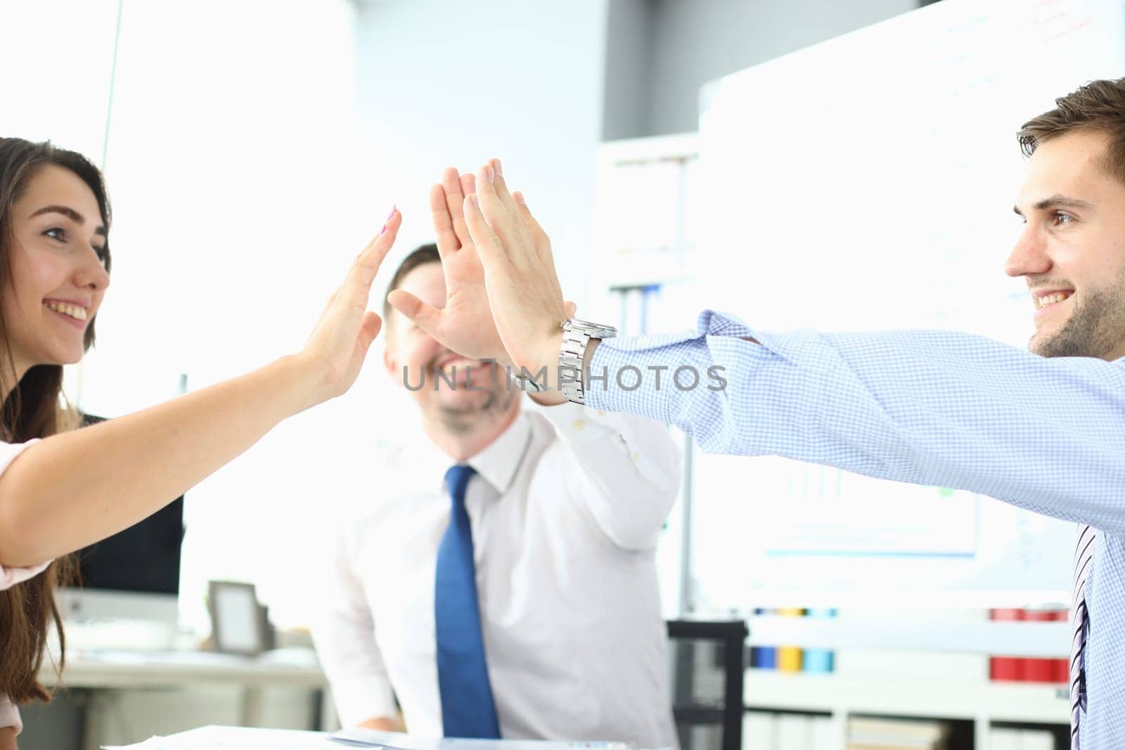 Happy business team high five in office. Business success and victory concept
