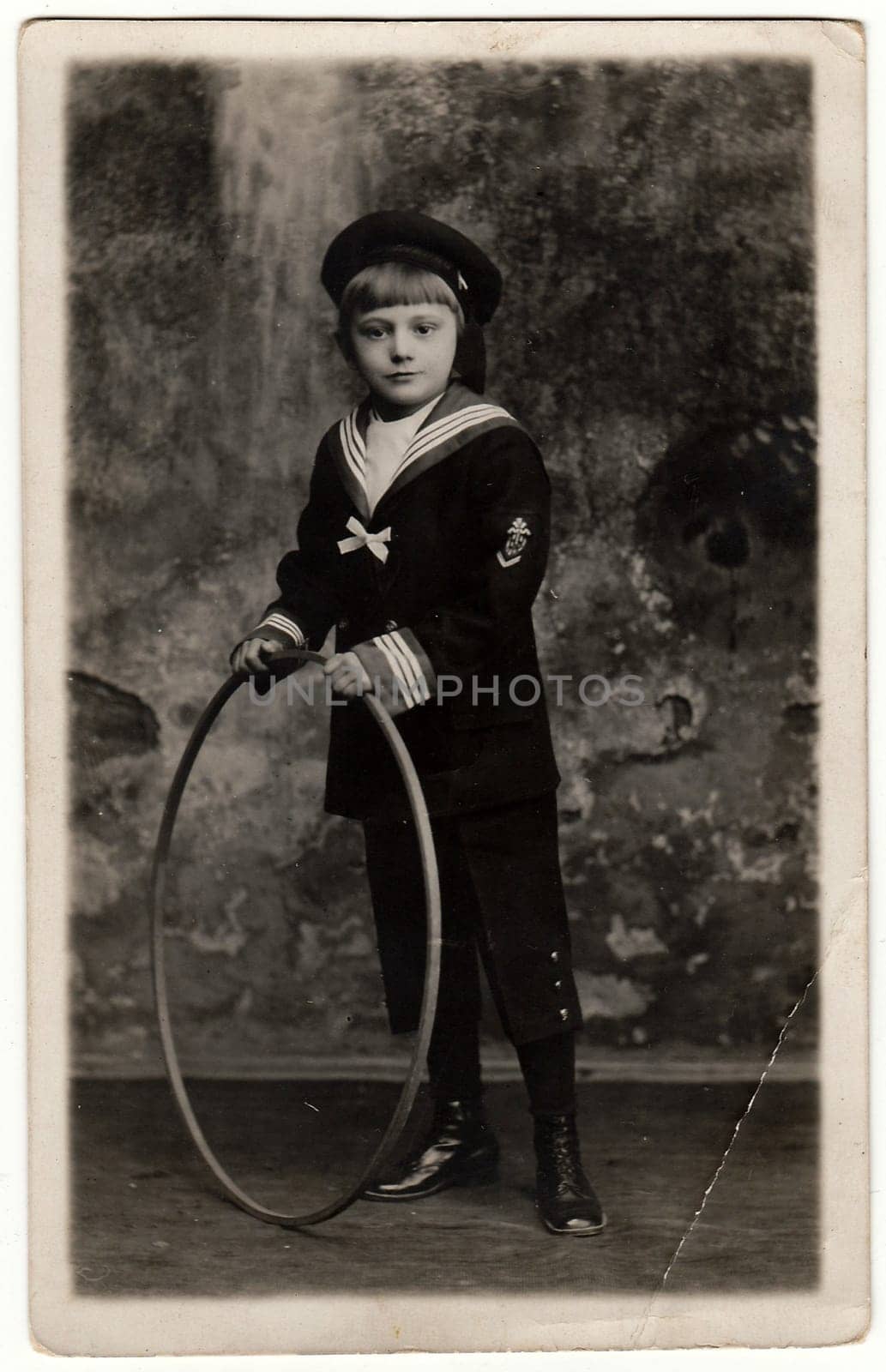 Vintage photo shows boy wears sailor costume with hoop. Antique black white photo. by roman_nerud