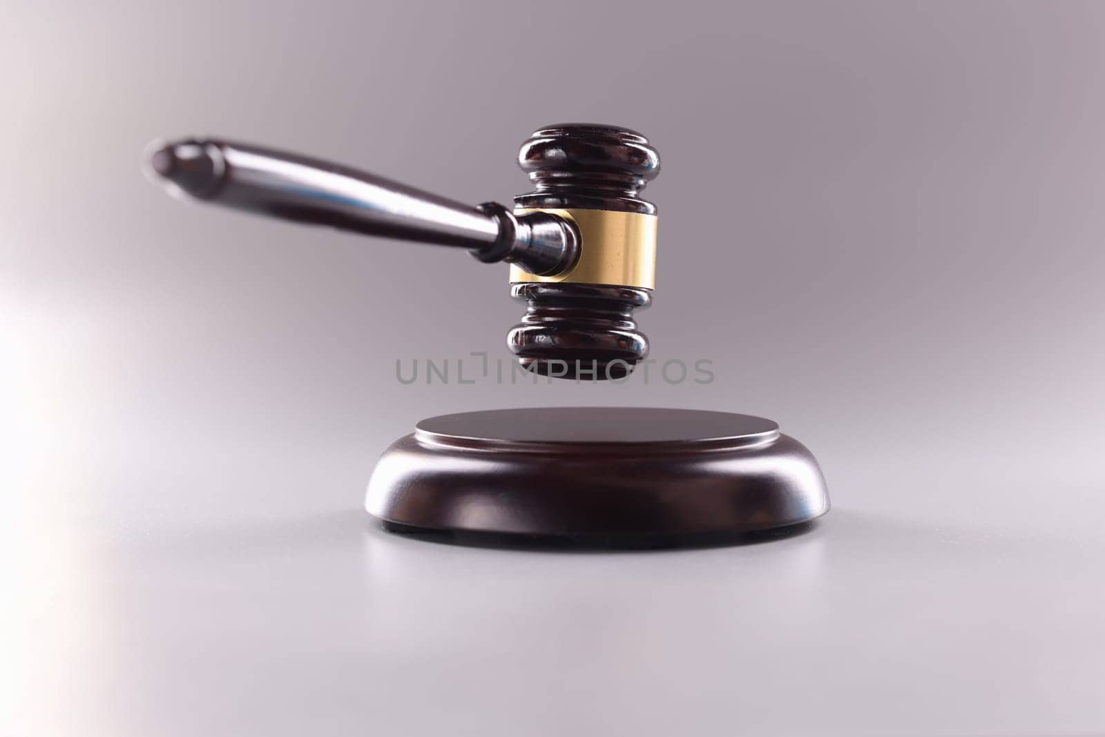 Wooden judge gavel in air on gray background. Judgment verdict or auction concept