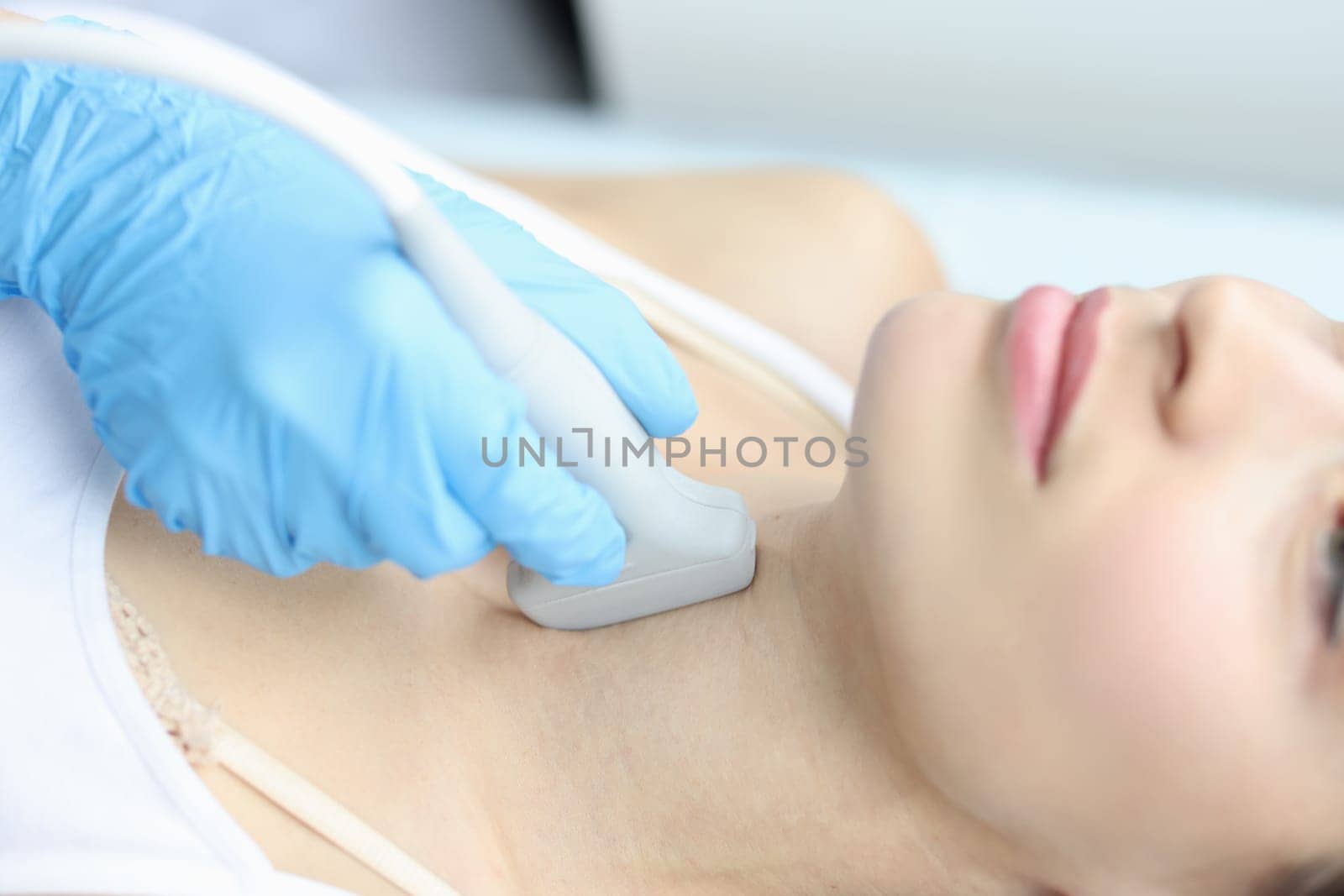 Scanning the thyroid gland of woman in medical clinic closeup. Research reflecting location of endocrine gland in women concept