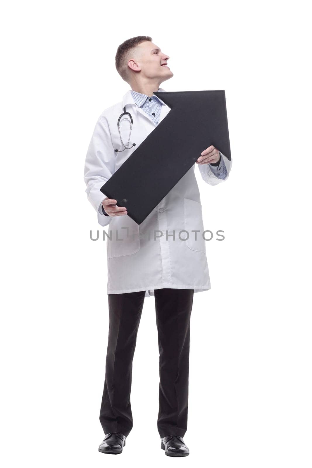 in full growth.smiling young doctor pointing in the right direction. isolated on a white background.